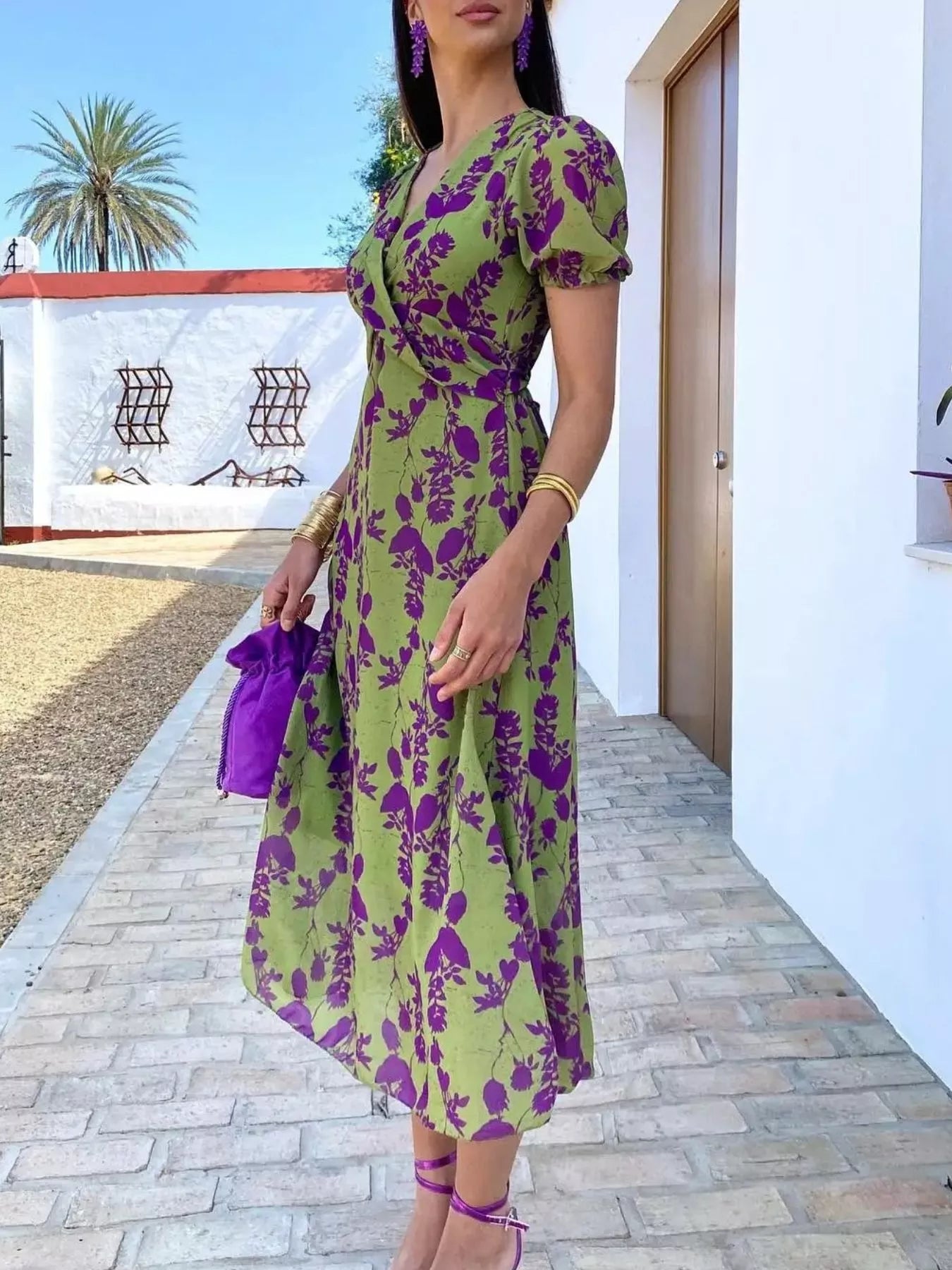 Green floral print midi dress with purple flowers, V-neckline, puff sleeves, and a fitted waist