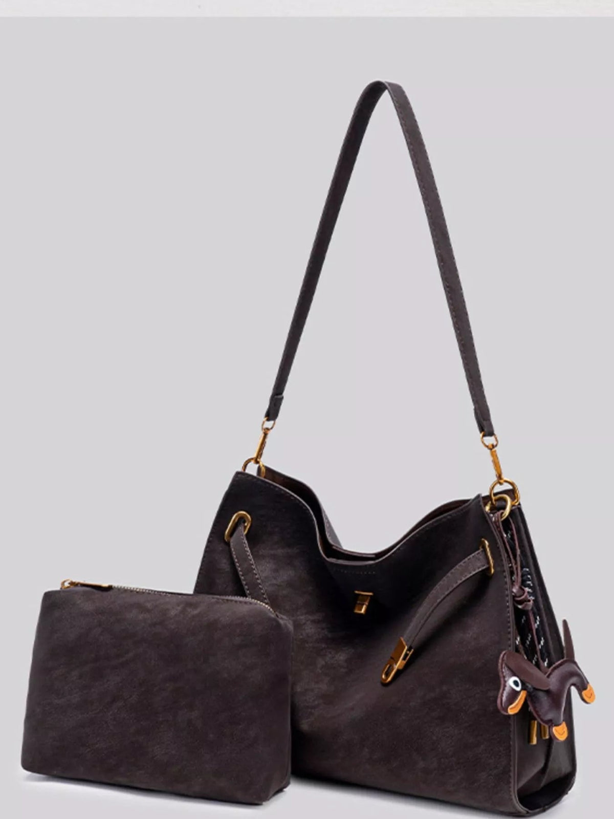 Dark brown suede crossbody bag with a roomy slouchy silhouette, long adjustable strap, gold-tone hardware, and decorative buckle detailing.