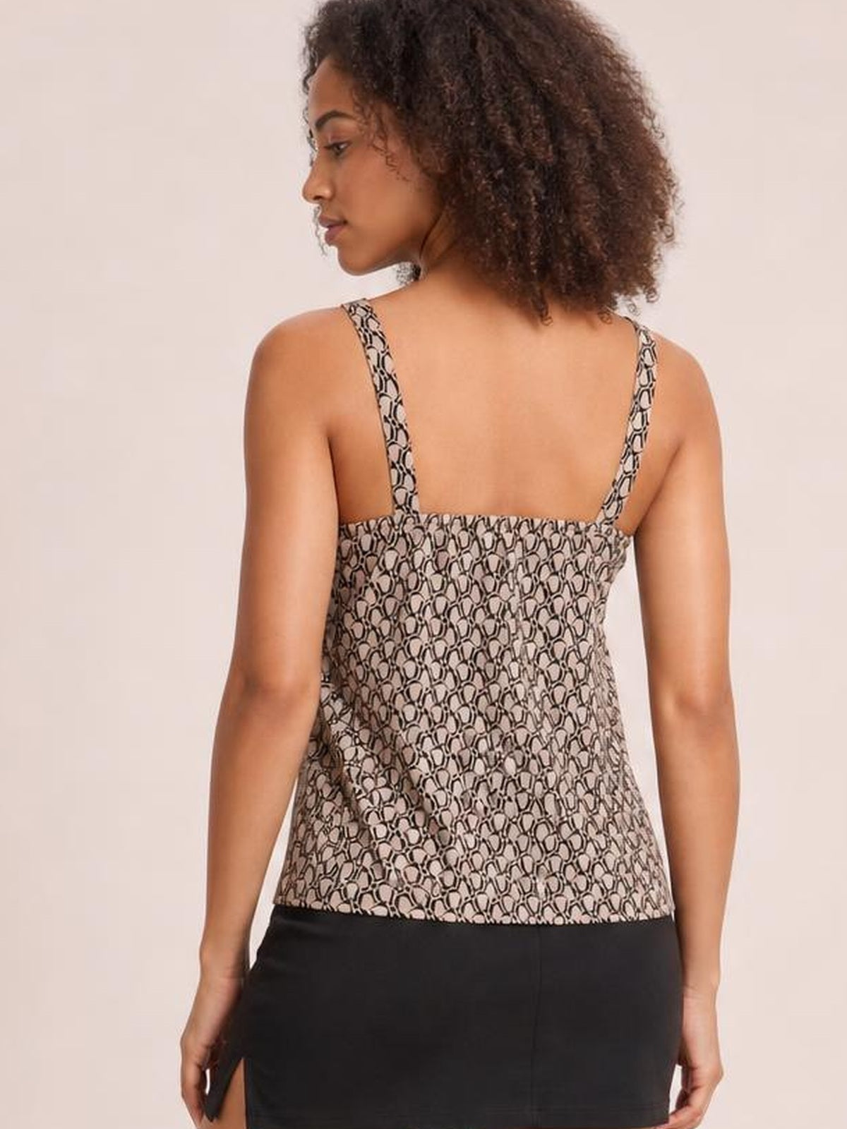 Model looks over her shoulder wearing a black and cream printed tank with thin straps, a square back neckline, and a relaxed straight silhouette.