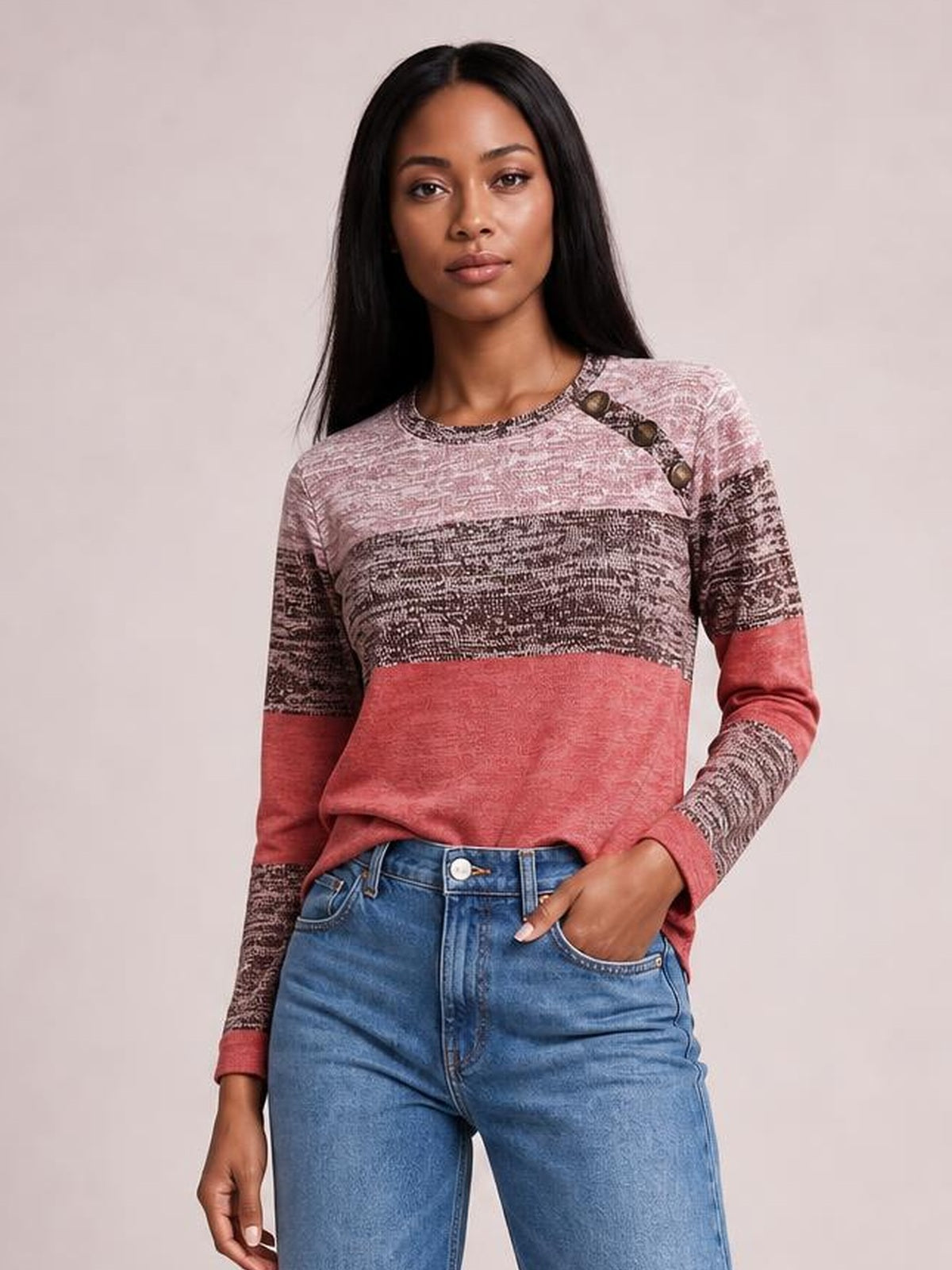 Model wearing a rose and brown contrast long-sleeve T-shirt with a round neck, decorative shoulder buttons, patterned panels, and a relaxed fit.