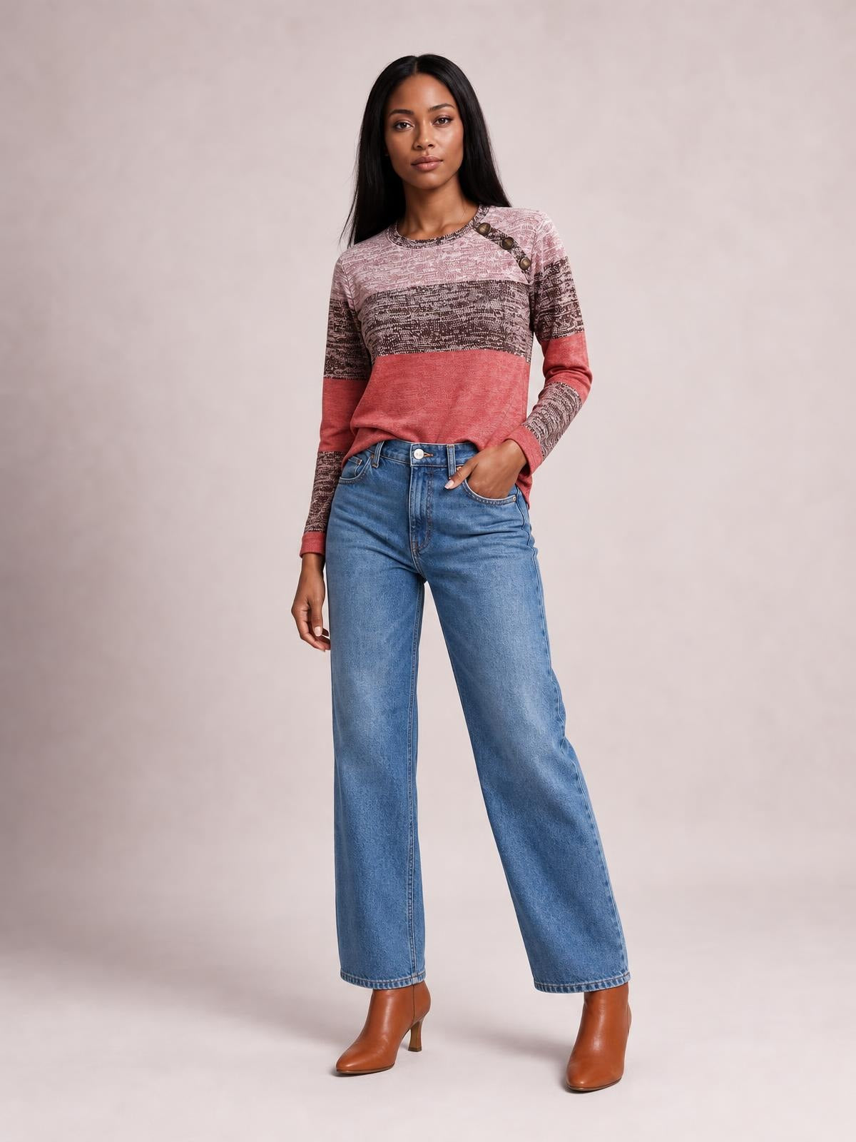 A model poses in a pink and charcoal contrast round-neck long-sleeve T-shirt with decorative shoulder buttons and a relaxed silhouette, one hand in her pocket.