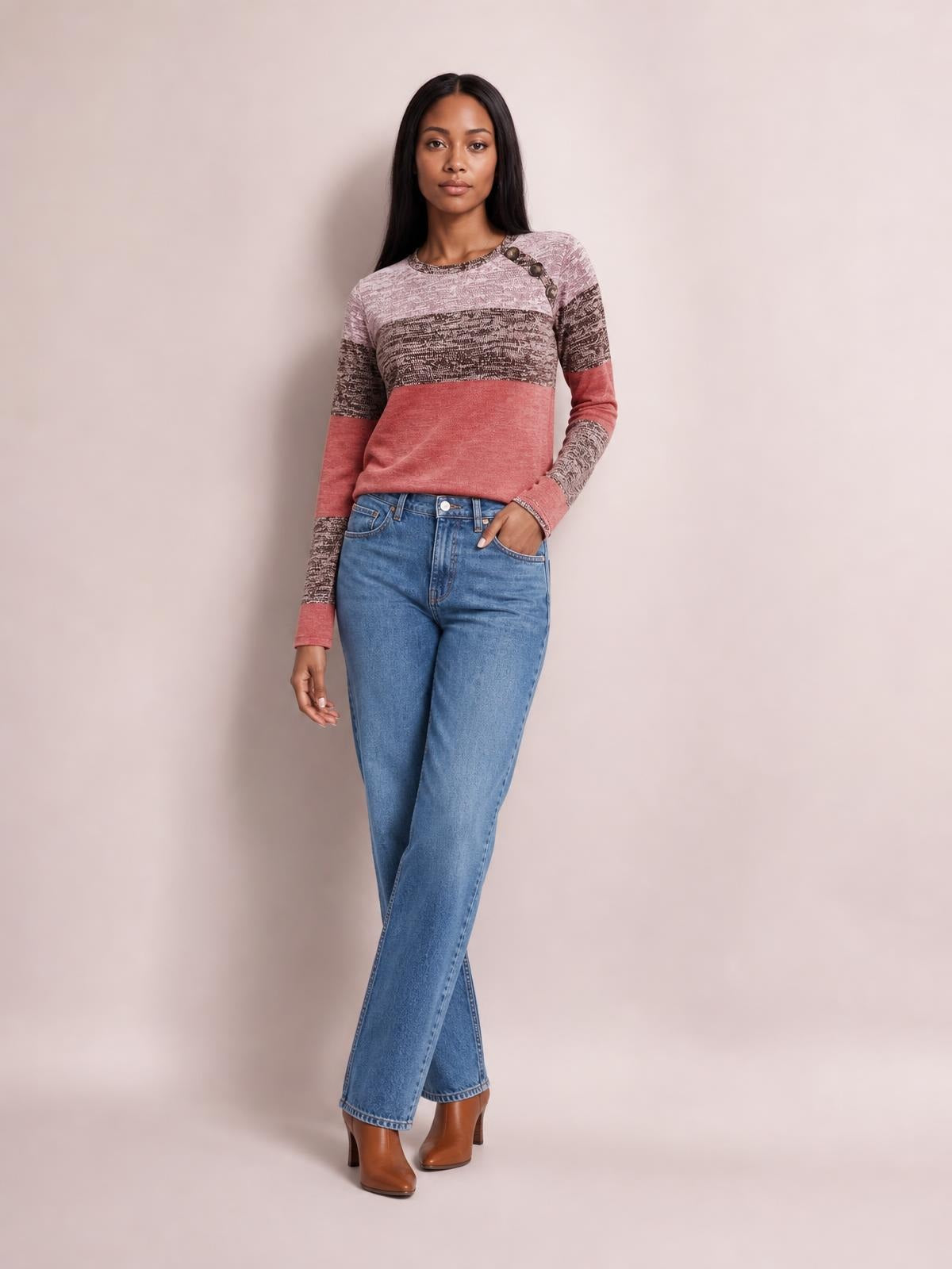 A model poses in a color-blocked long-sleeve T-shirt with a round neck, decorative shoulder buttons, pink, mauve, and charcoal panels, and a relaxed silhouette.
