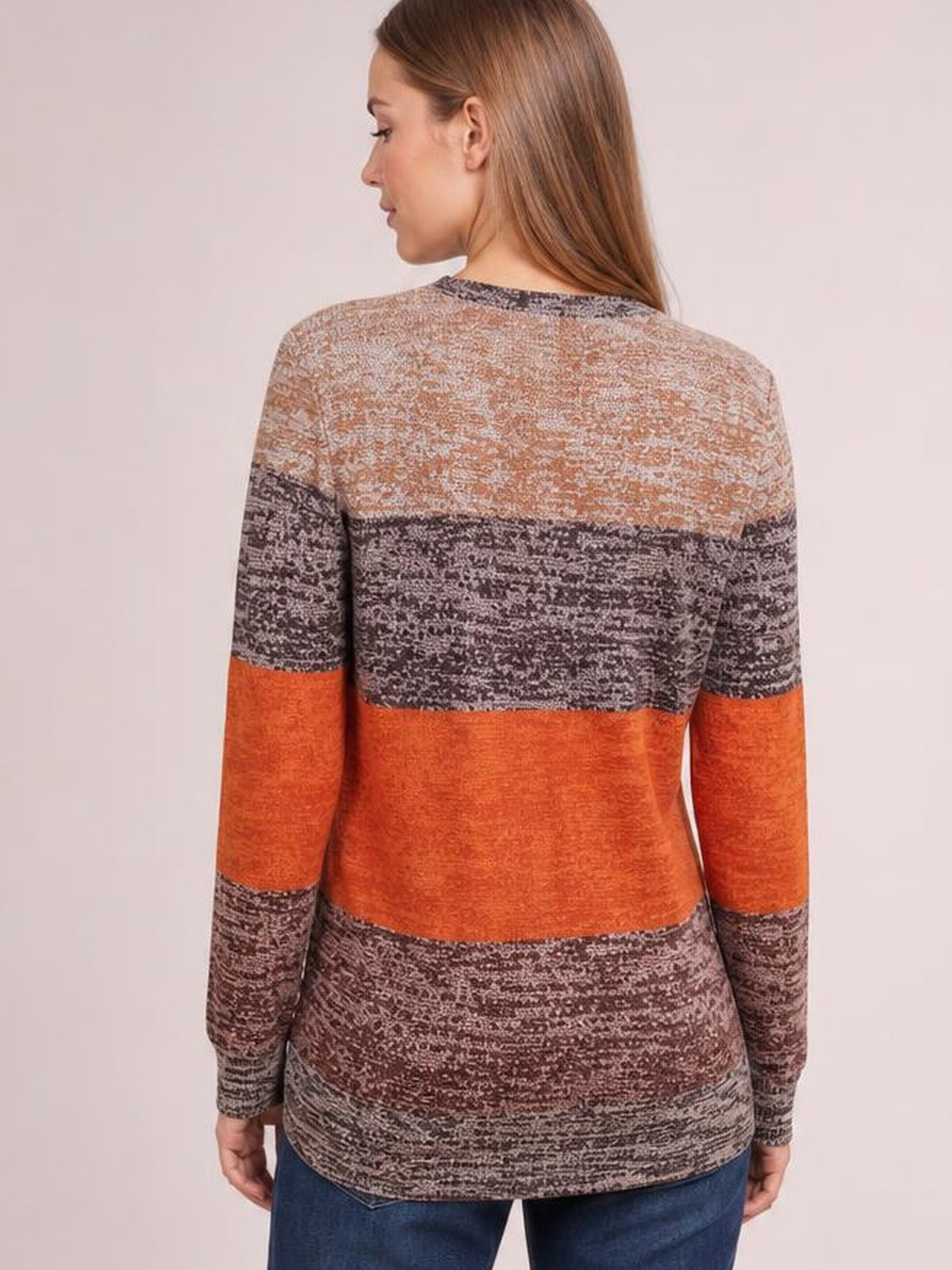 Model shown from the back in a relaxed pose wearing an opaque long-sleeve T-shirt with a round neck, color-blocked orange, brown, and gray patterned design.