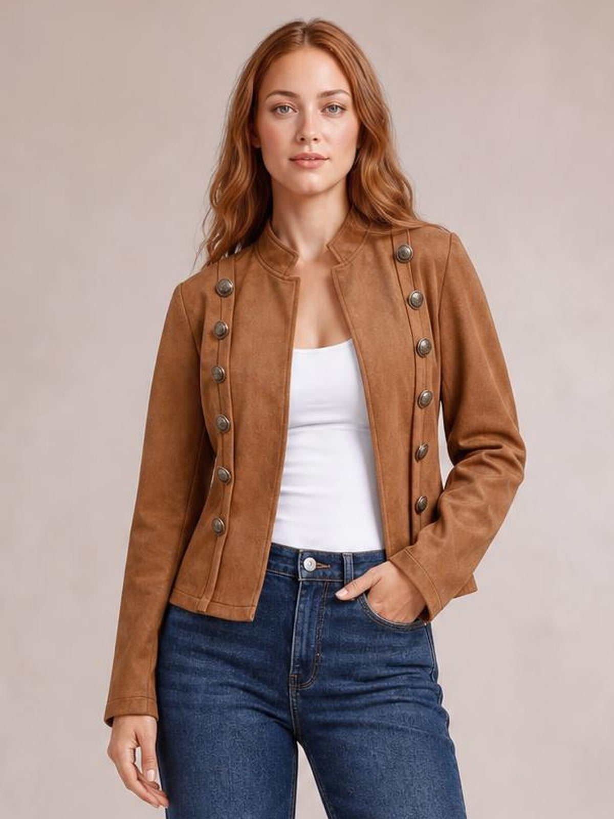Model wearing a fitted tan open-front jacket with long sleeves, decorative buttons, structured trim, and a cropped silhouette over a white top.