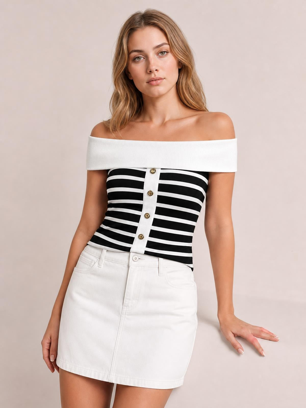 A model poses in a fitted black-and-white striped knit top with an off-shoulder white ribbed neckline and decorative button placket.