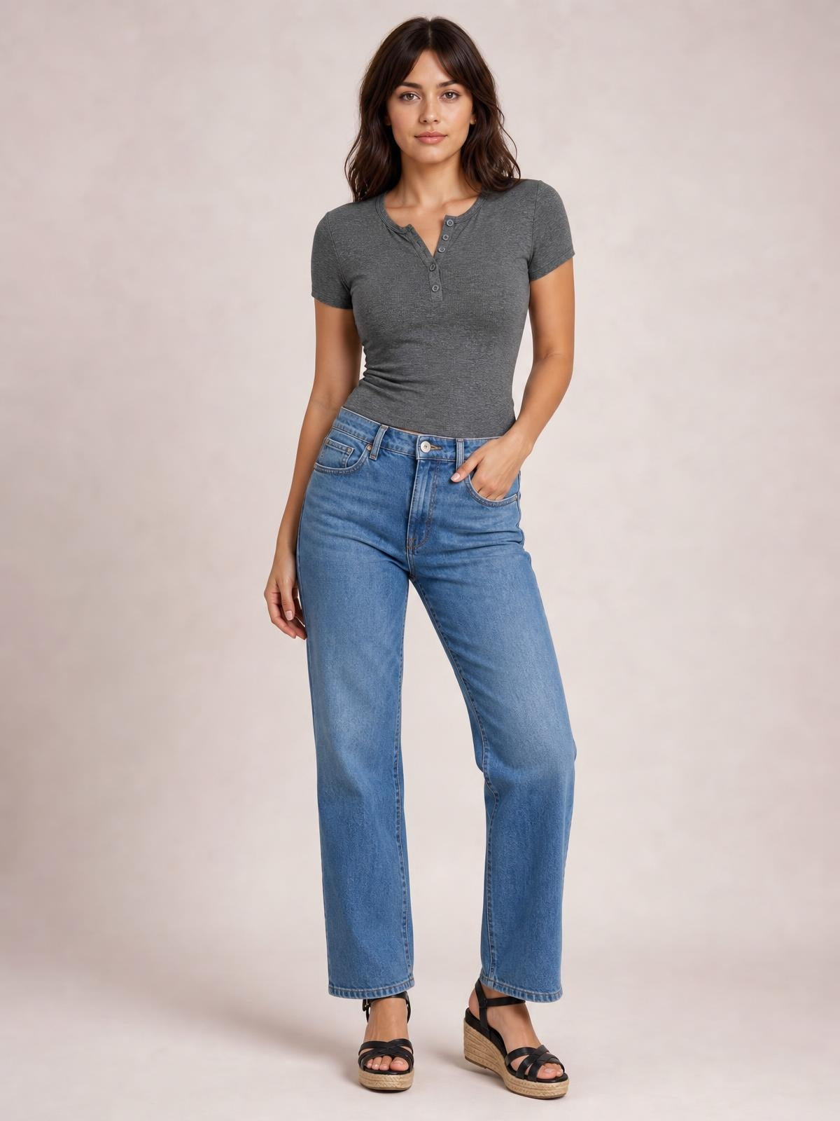Model wearing a fitted charcoal gray short-sleeve T-shirt with a round neckline and button-front detail, paired with straight-leg blue jeans.