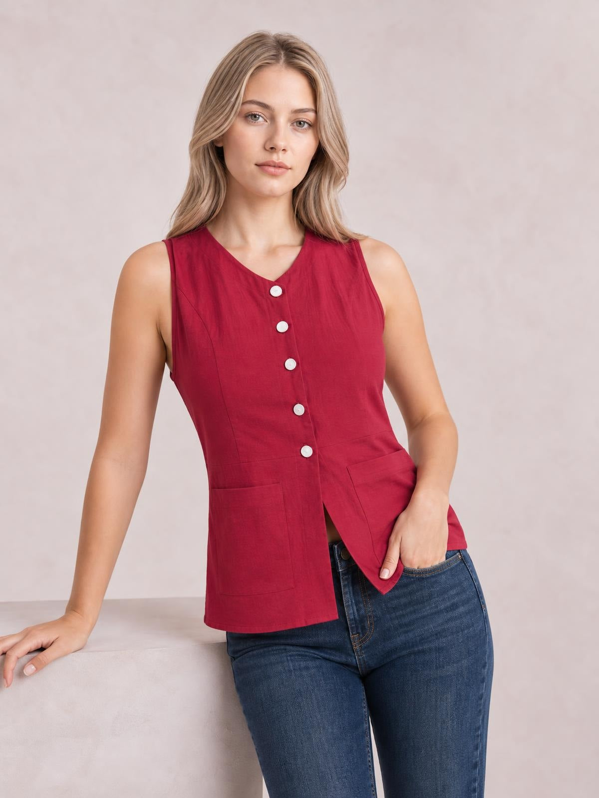 A model poses in a red sleeveless V-neck top with a button-down front, shaped silhouette, and two large patch pockets.