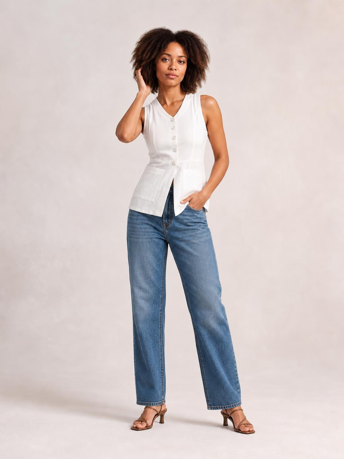 A model poses in a white sleeveless V-neck top with a button-down front, fitted waist, and large patch pockets for a structured silhouette.