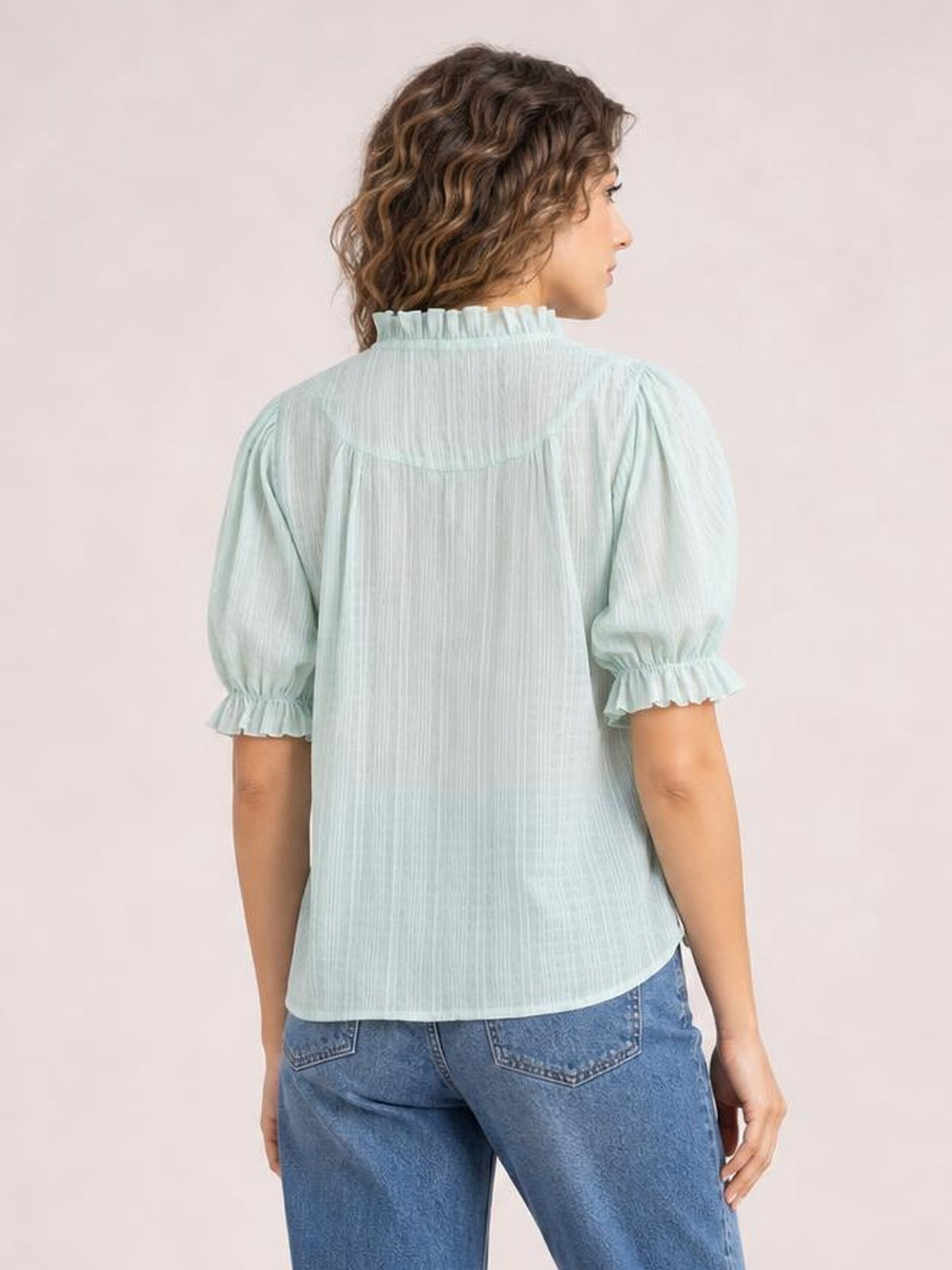 Back view of a light mint frill blouse with a ruffled neckline, ruched puff short sleeves, vertical texture, and a relaxed straight silhouette.