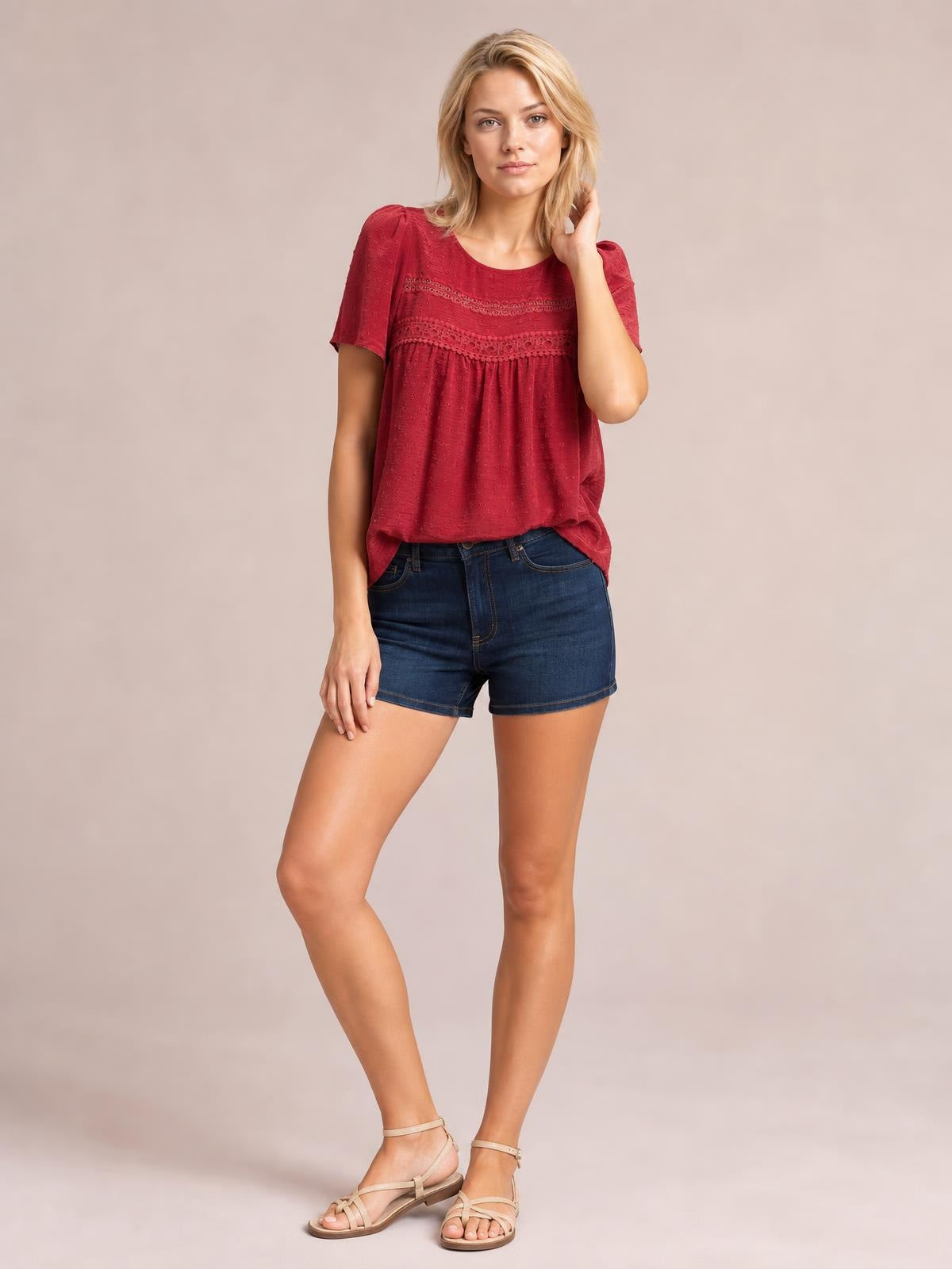 Model poses in a burgundy short-sleeve blouse with a round neck, lace detail, ruched yoke, and relaxed silhouette.