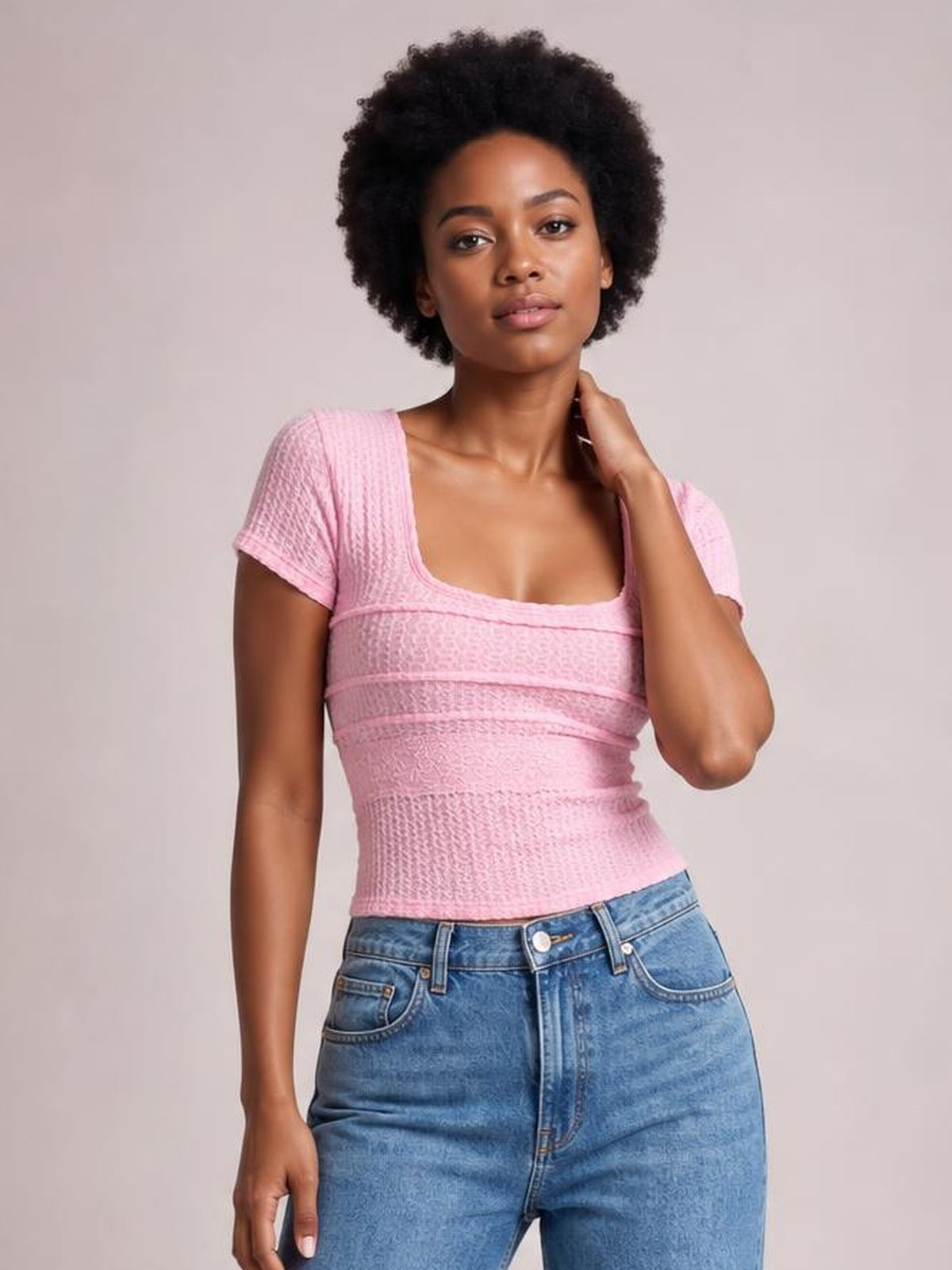 A model poses in a fitted pink square-neck short-sleeve T-shirt with lace detail, textured construction, and a slightly stretchy silhouette.