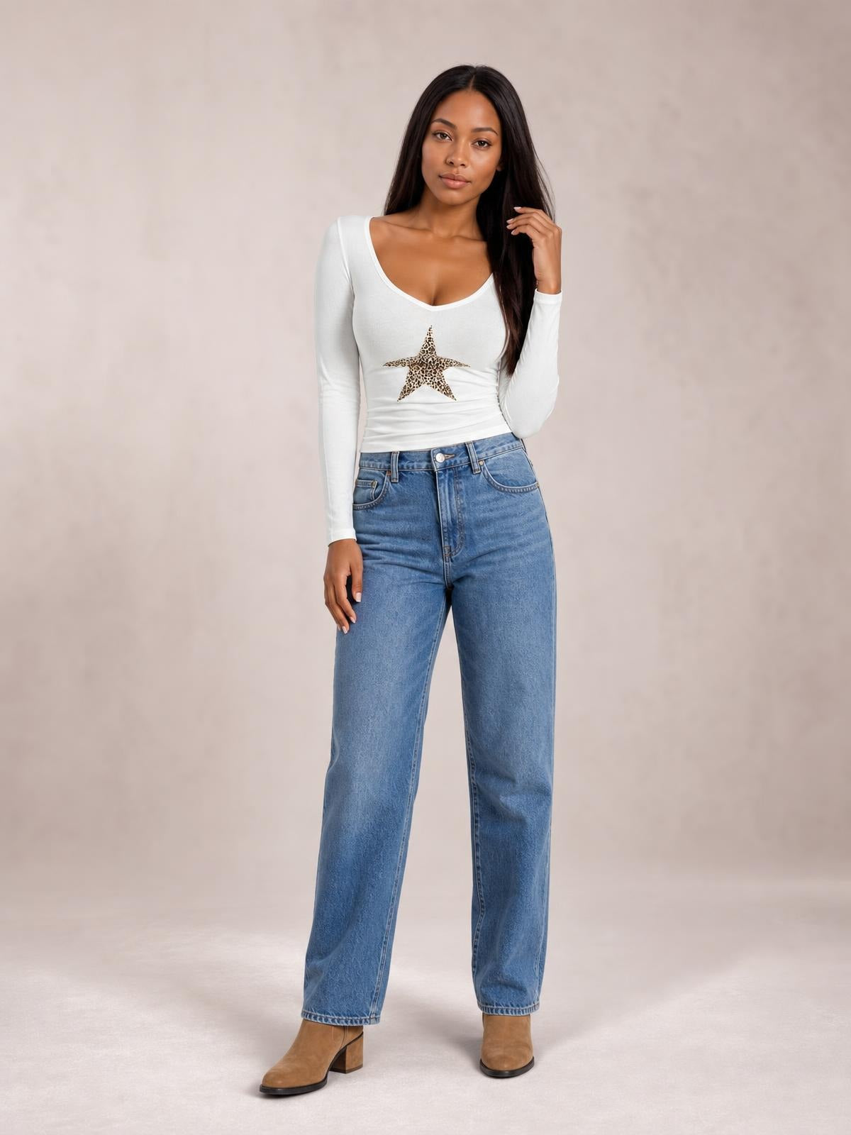 A model poses in a white Leopard Star long sleeve T-shirt with a scoop neckline, fitted silhouette, and central leopard-print star graphic.