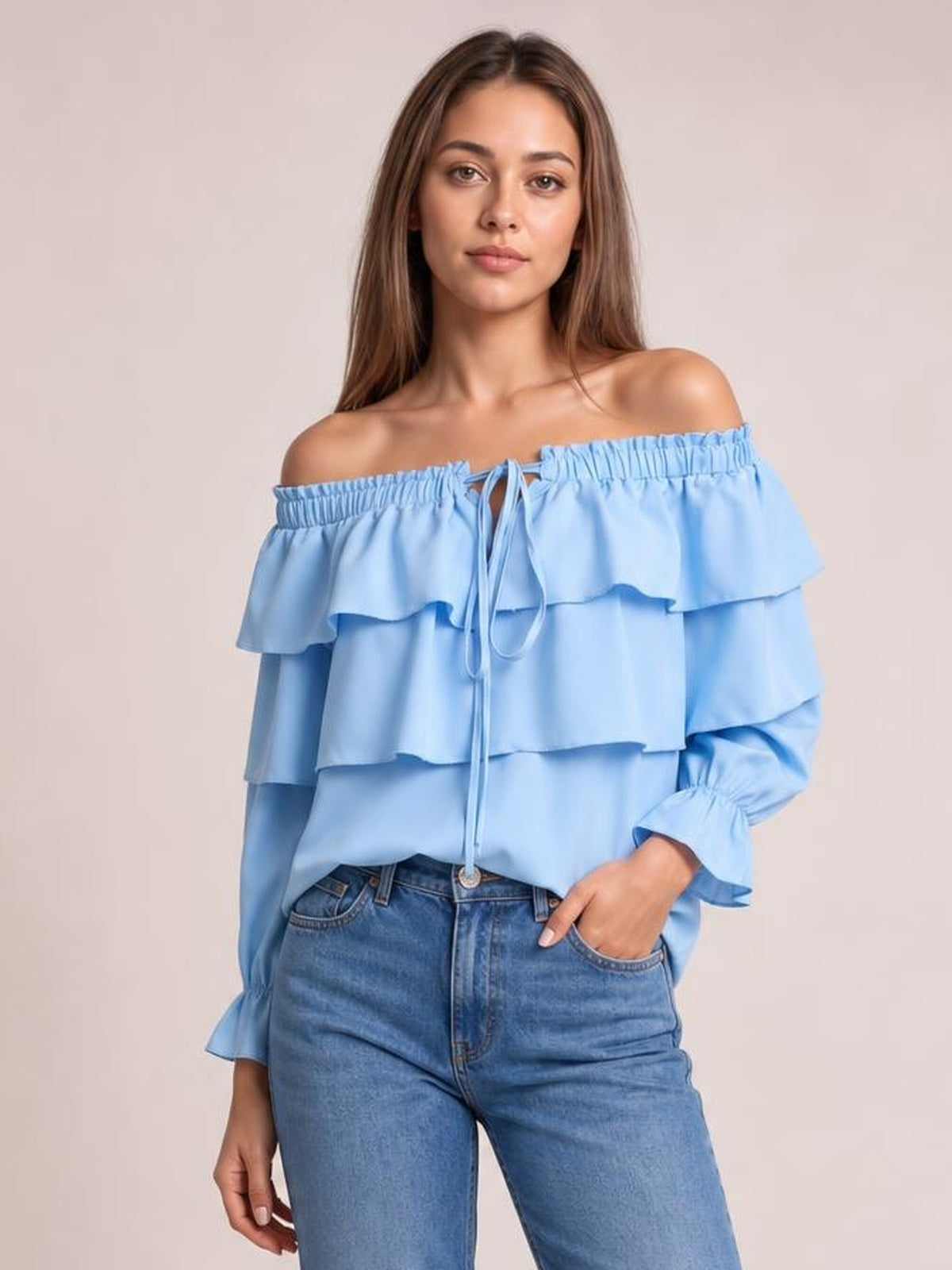 Model wearing a light blue off-shoulder blouse with layered ruffled flounce sleeves, a drawstring neckline, and a relaxed silhouette.