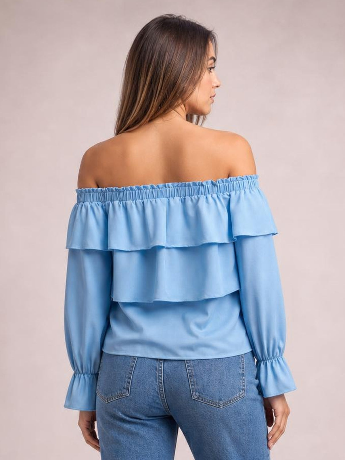 A model shows the back of a light blue off-shoulder blouse with layered ruffled flounce sleeves, gathered neckline, and a relaxed silhouette.