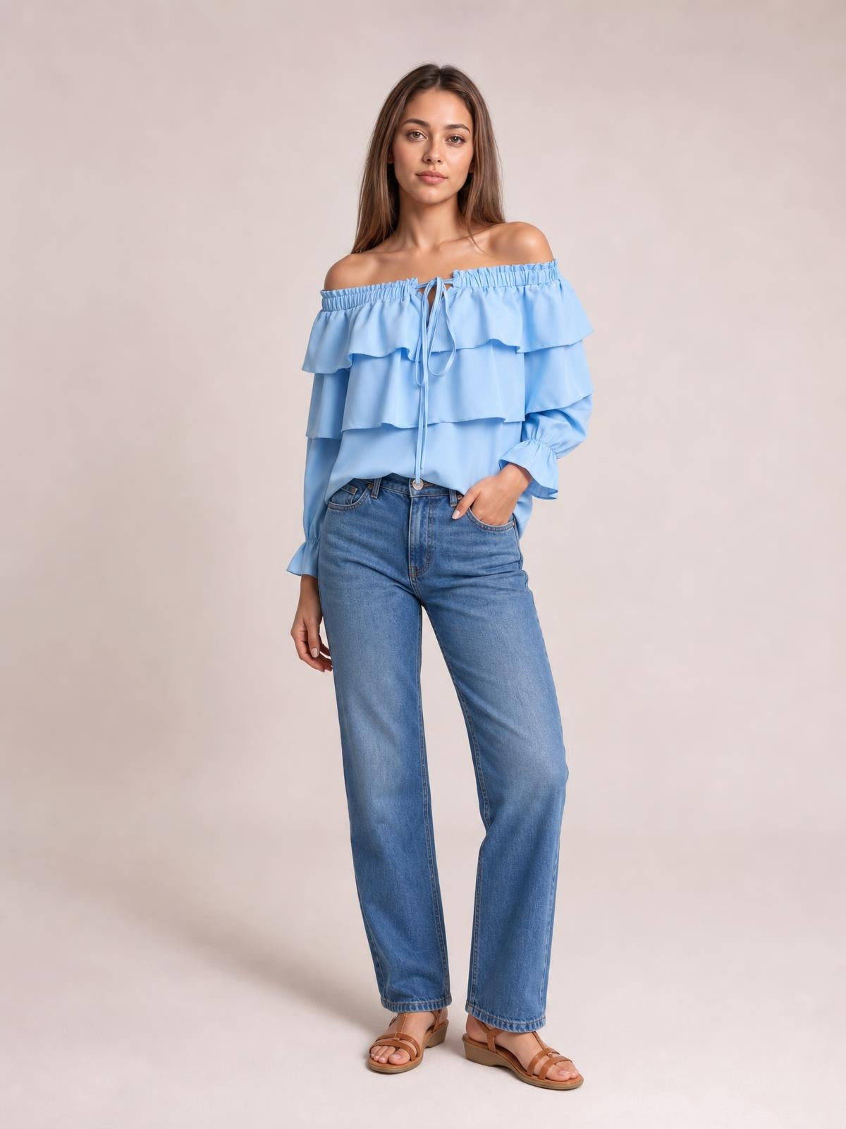 Model poses in a light blue off-shoulder blouse with a drawstring neckline, layered ruffled flounce sleeves, and a relaxed silhouette.