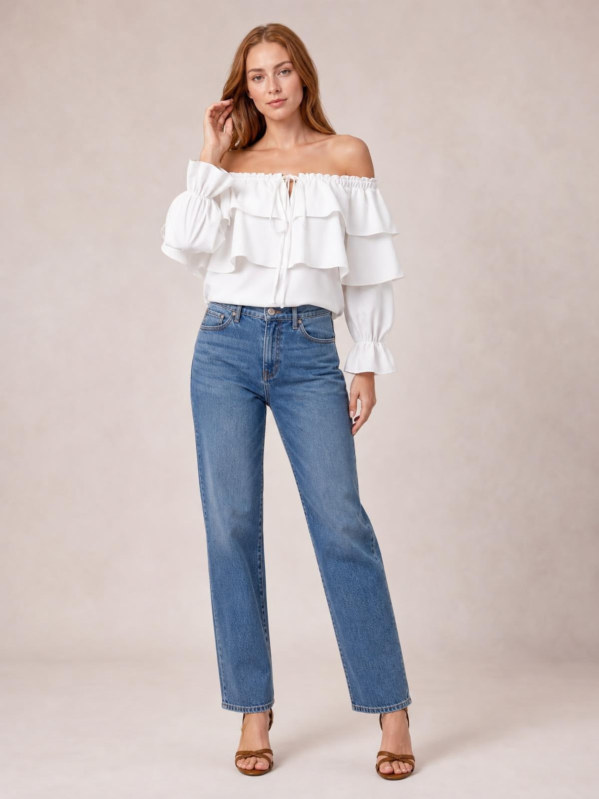 Model poses in a white off-shoulder blouse with layered ruffled flounce sleeves, gathered cuffs, a drawstring neckline, and a relaxed silhouette.