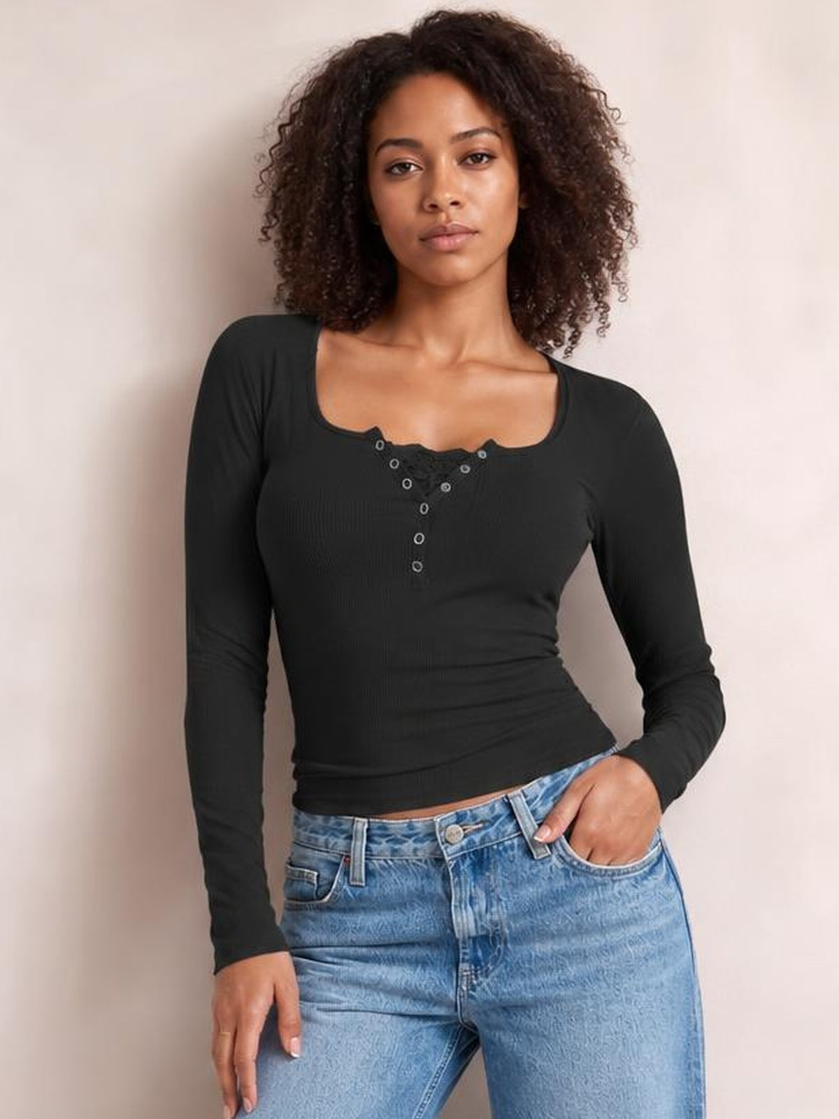 A model poses in a fitted black square-neck half-snap long-sleeve T-shirt with a button placket and slim silhouette, one hand resting in her jeans pocket.