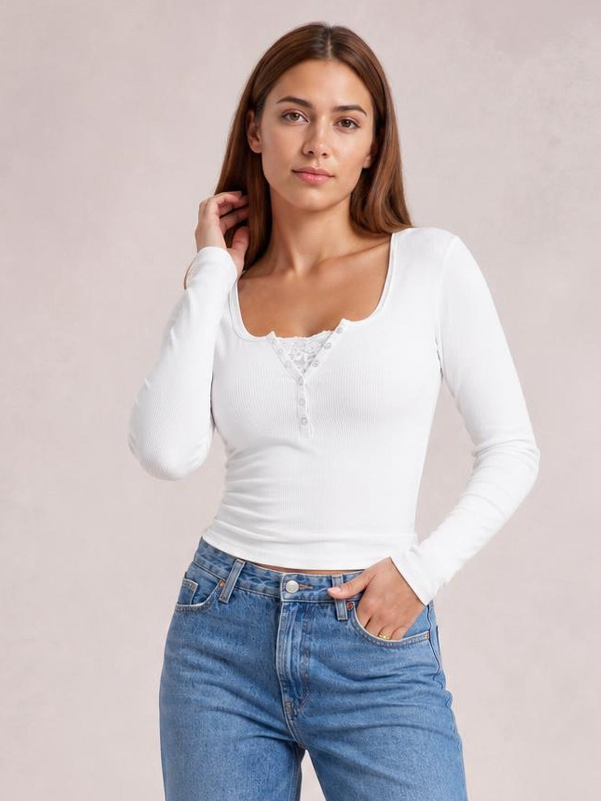 Model wears a fitted white square-neck half-snap long-sleeve T-shirt with a ribbed texture and button placket, posing with one hand in her jeans pocket.