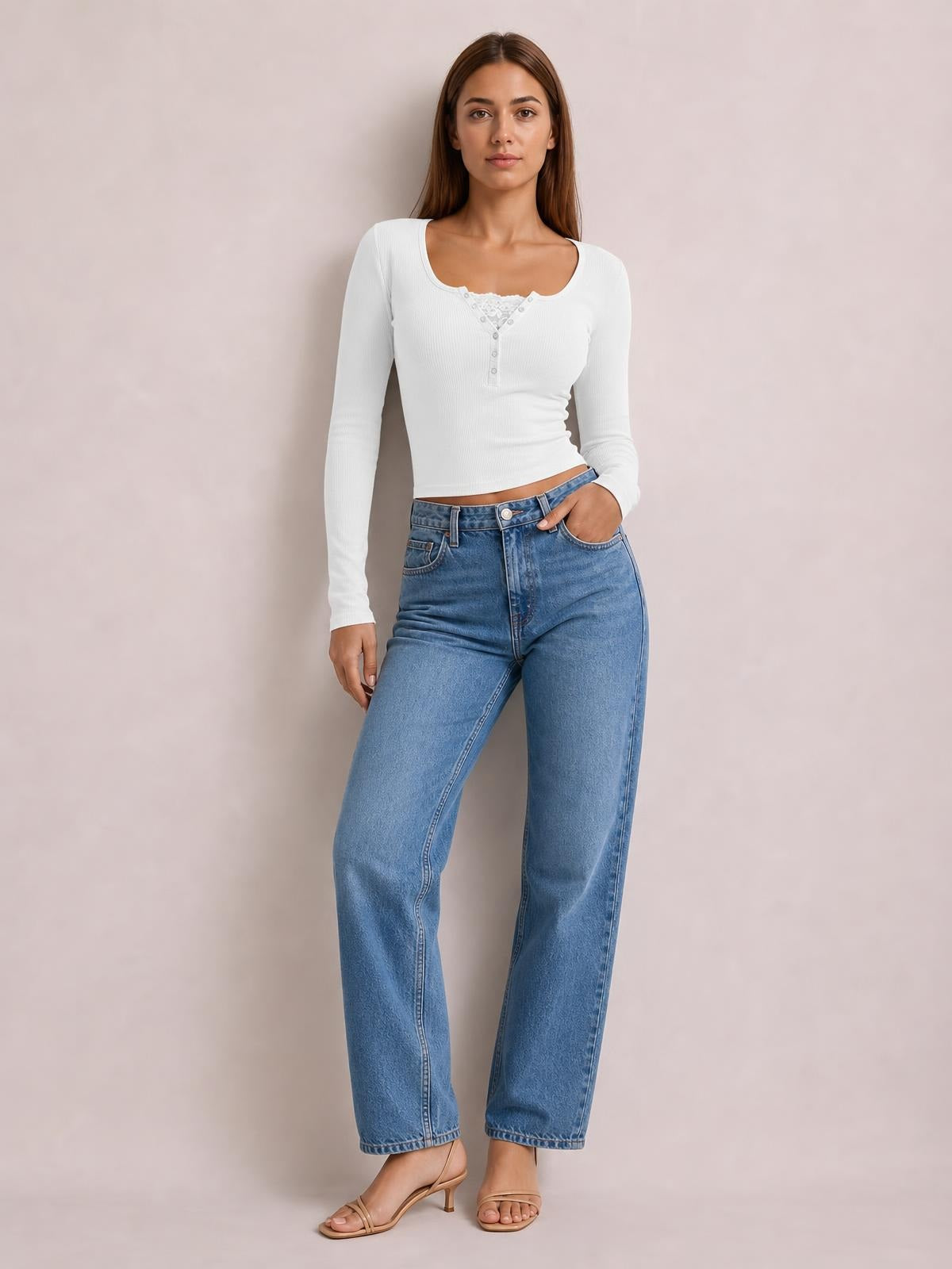 A model poses in a fitted white square-neck long-sleeve T-shirt with a buttoned half-snap placket and cropped silhouette, paired with wide-leg jeans.