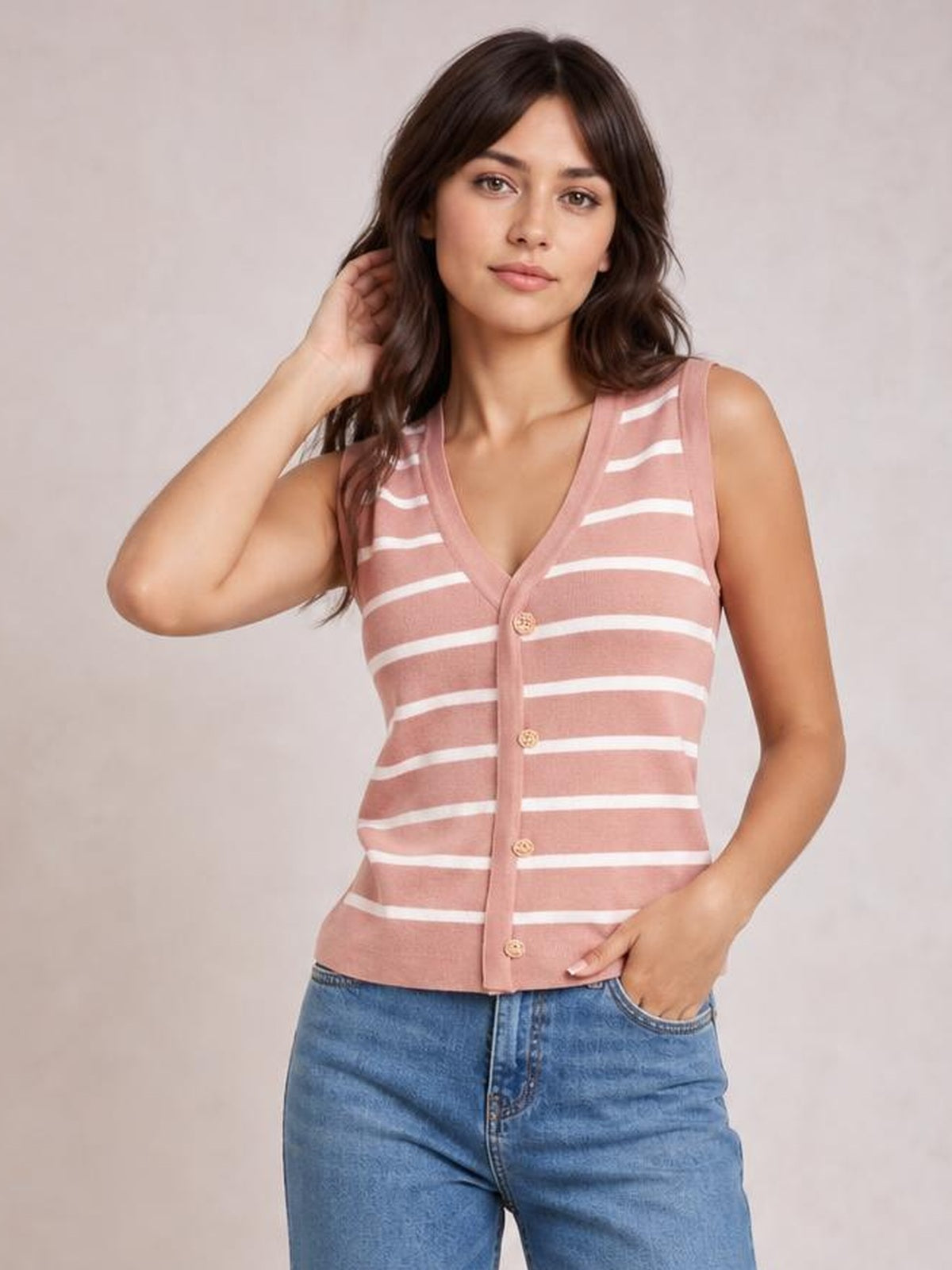 Model poses in a dusty rose striped V-neck knit tank with sleeveless styling, button-front construction, and a fitted waist-length silhouette.