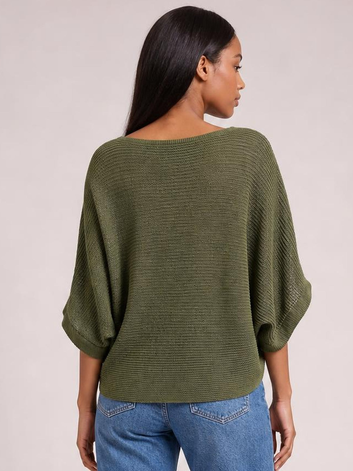 A model shown from behind wears an olive green knit top with relaxed batwing sleeves, a wide back neckline, and a loose, boxy silhouette.