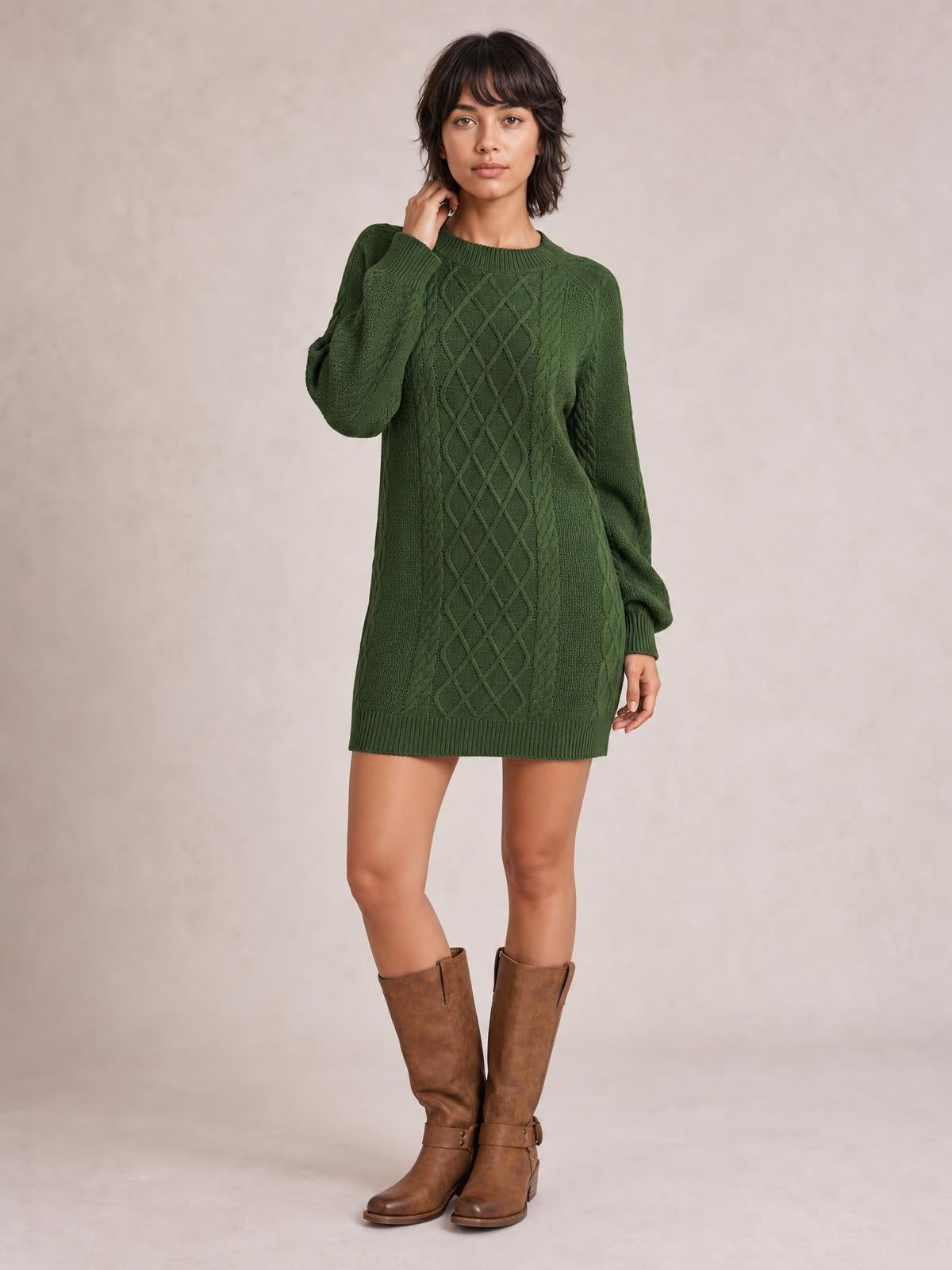 Model poses in a forest green diamond cable-knit sweater dress with long sleeves, ribbed crew neck and hem, and a relaxed straight silhouette.