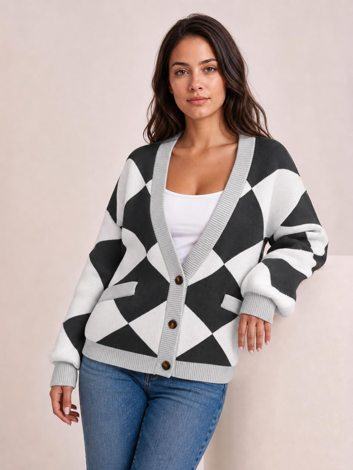 Model wearing a relaxed black-and-white diamond pattern knit cardigan with gray ribbed trim, button front, patch pockets, and dropped sleeves.