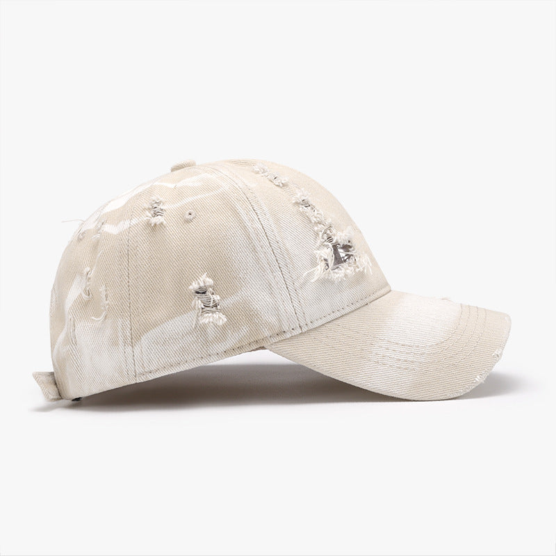 Distressed beige cotton baseball cap with a structured six-panel crown, curved brim, frayed worn details, and an adjustable back strap.