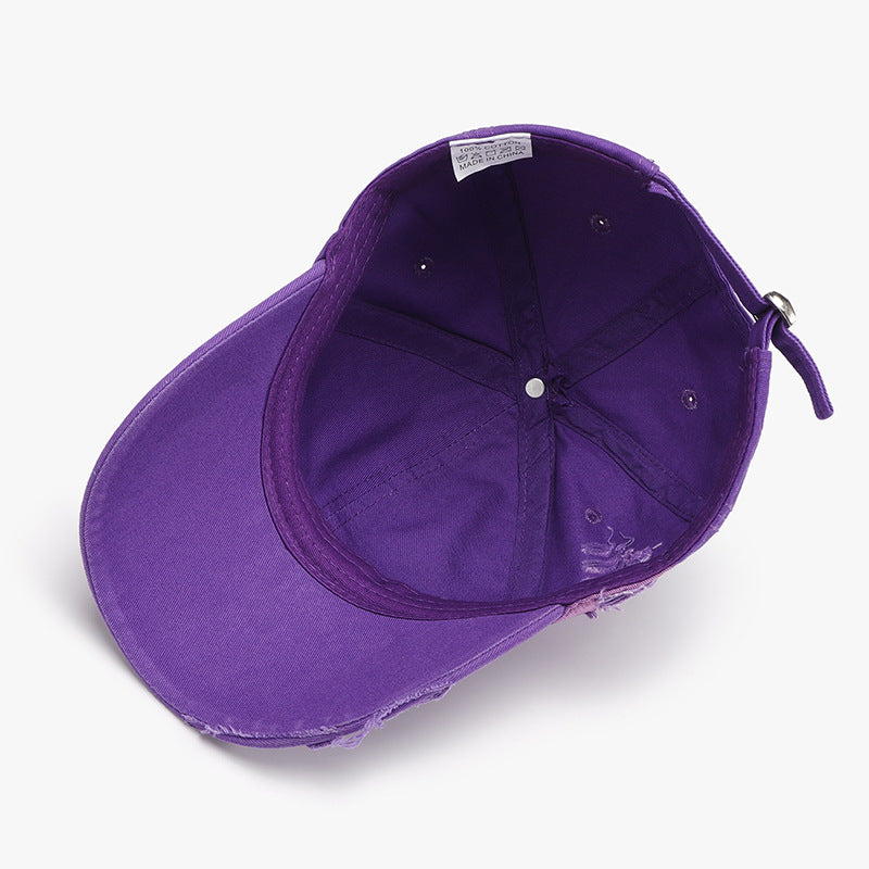 Purple distressed cotton baseball cap shown from inside, featuring a six-panel construction, curved brim, tonal stitching, and an adjustable back strap.