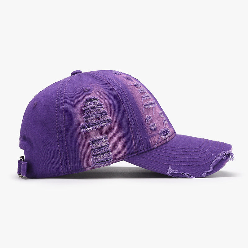 Purple distressed cotton baseball cap with a six-panel crown, curved brim, tonal stitching, frayed accents, and an adjustable back strap.