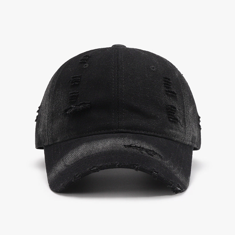 Black distressed cotton baseball cap with a structured six-panel crown, curved brim, center seam, and frayed worn accents across the front and visor.