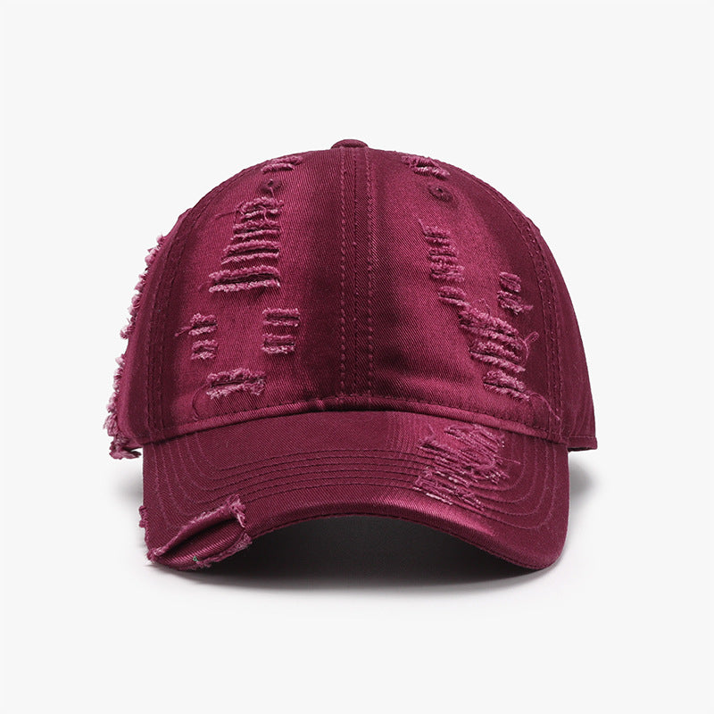 Burgundy distressed cotton baseball cap with a six-panel crown, gently curved brim, tonal stitching, and frayed worn-in details across the front.