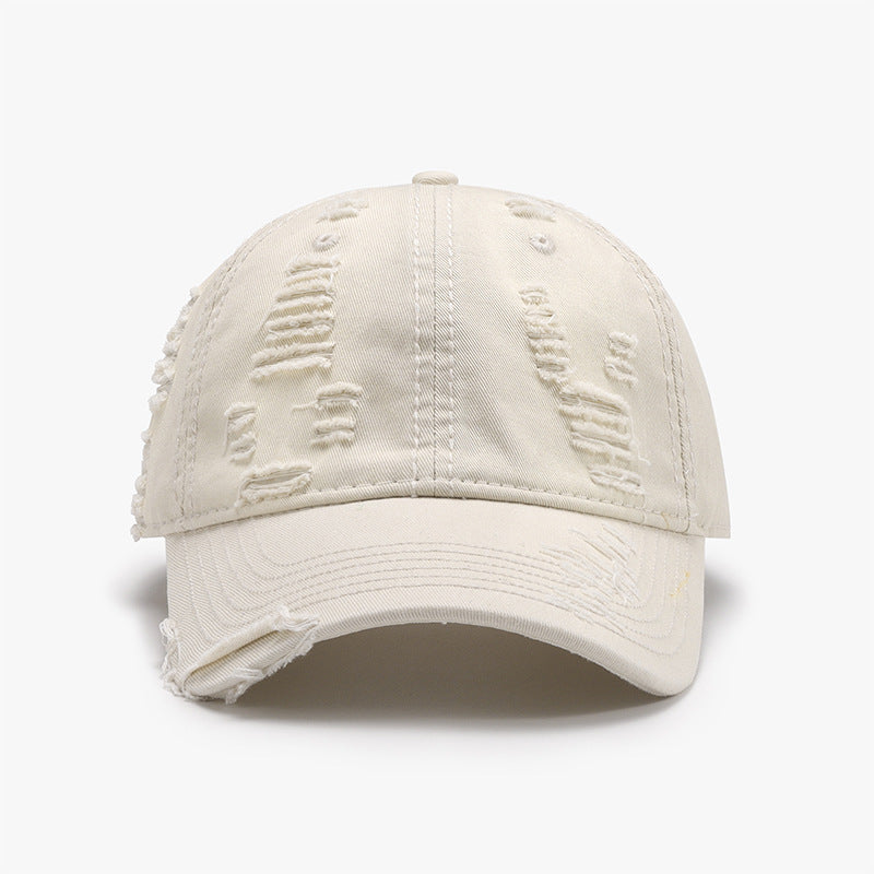 Distressed cream cotton baseball cap with a classic six-panel crown, curved brim, tonal stitching, and frayed details for a worn-in casual style.