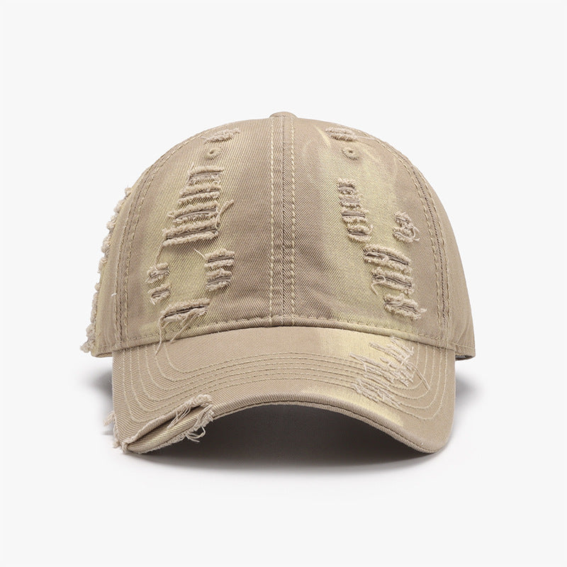 Distressed beige cotton baseball cap with a six-panel crown, curved brim, tonal stitching, and frayed details across the crown and brim.