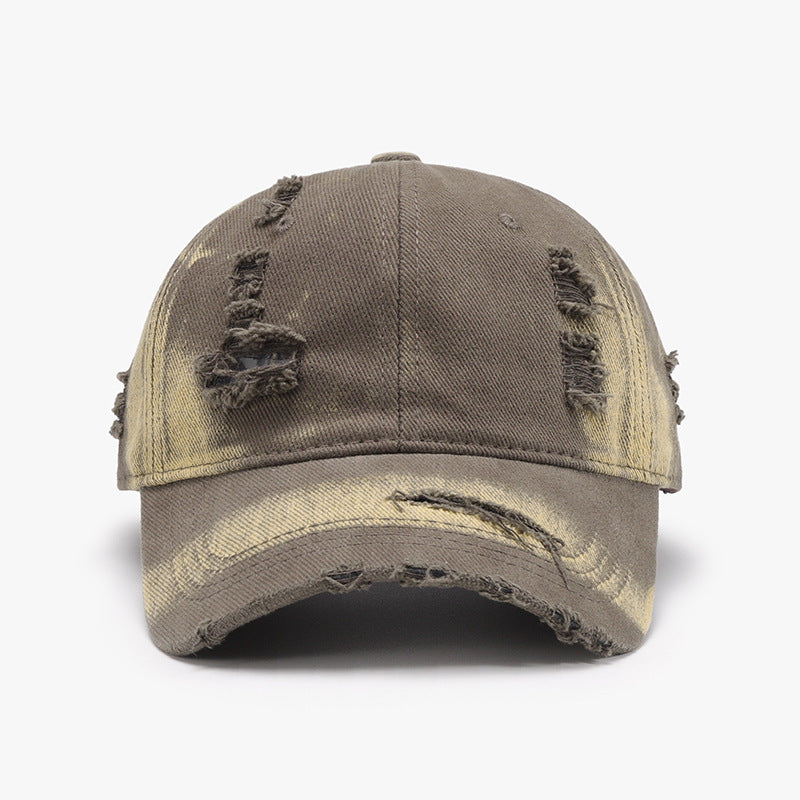 A distressed brown cotton baseball cap features a structured six-panel crown, curved brim, adjustable back, and frayed worn details for a relaxed finish.