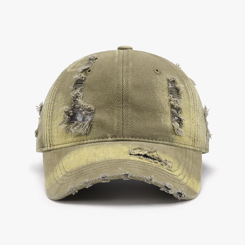 Distressed olive cotton baseball cap with a structured six-panel crown, curved brim, visible frayed tears, worn edges, and a relaxed vintage finish.