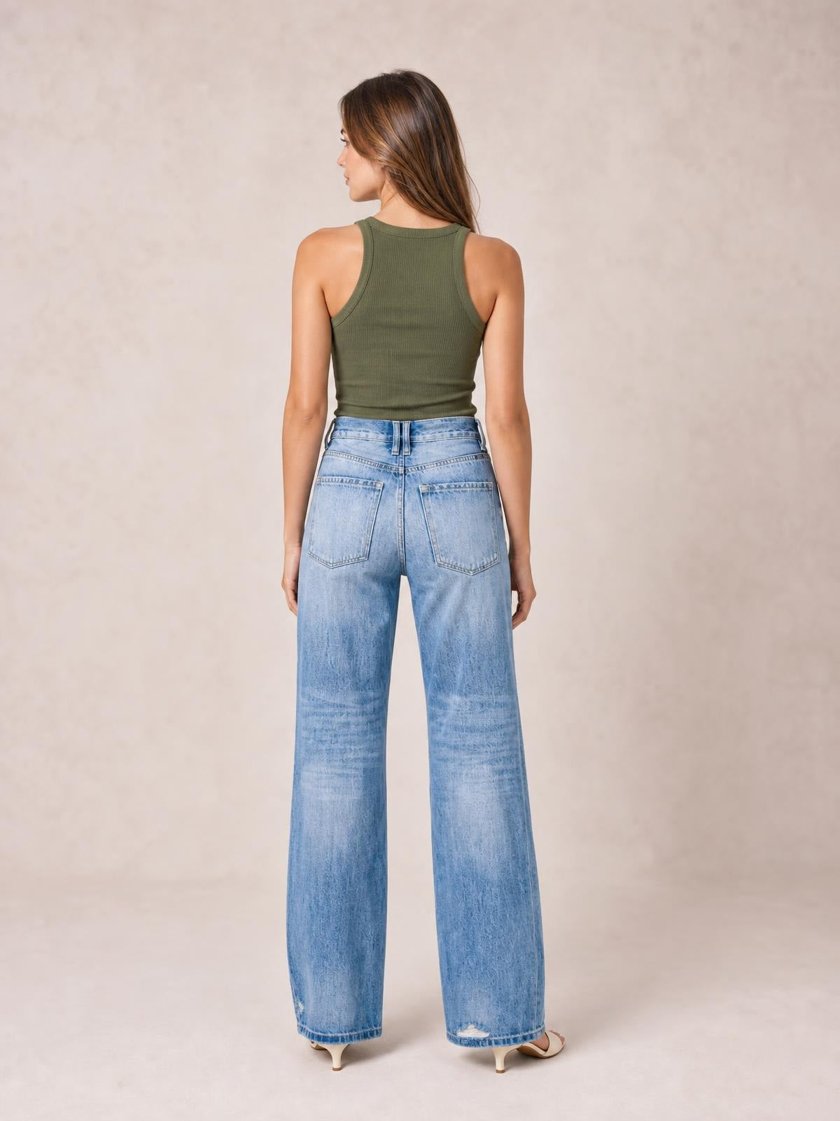 Model shown from the back wearing light blue distressed straight-leg jeans with a high waist, belt loops, rear patch pockets, and wide hems.
