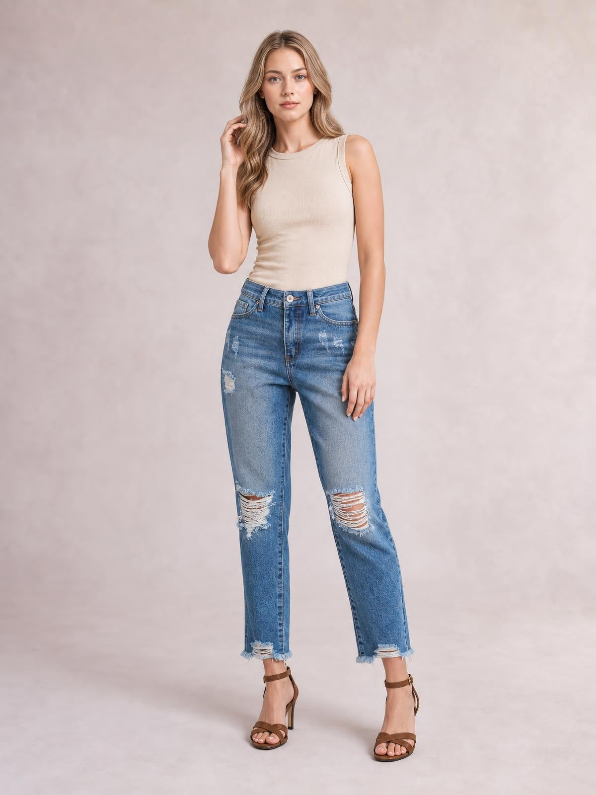 Model wears blue distressed wash ankle jeans with a straight-leg silhouette, ripped knees, five-pocket construction, belt loops, and raw hems.
