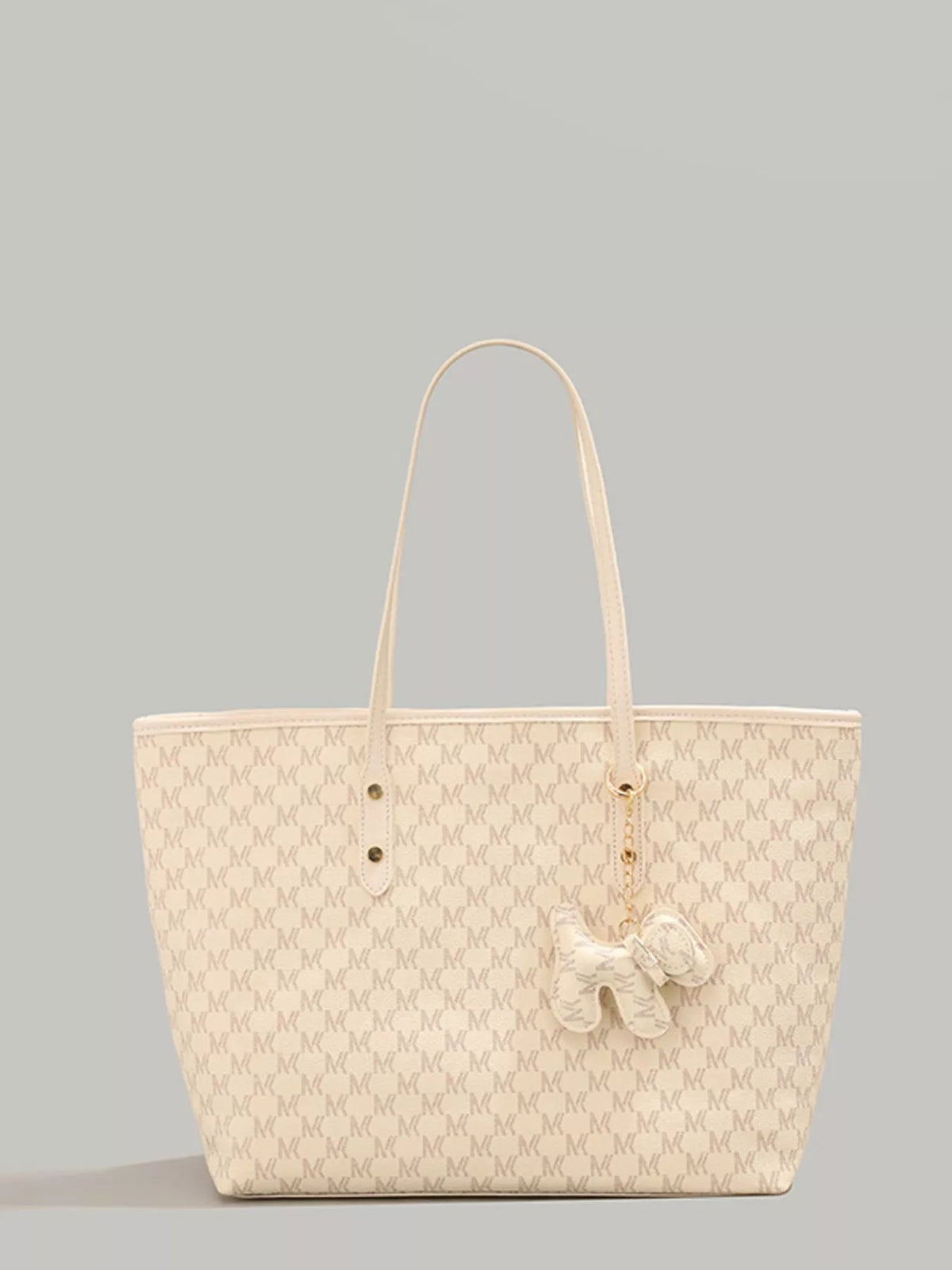 Large cream PU leather tote bag with long handles, a structured spacious silhouette, repeating monogram pattern, and a dangling dog charm.