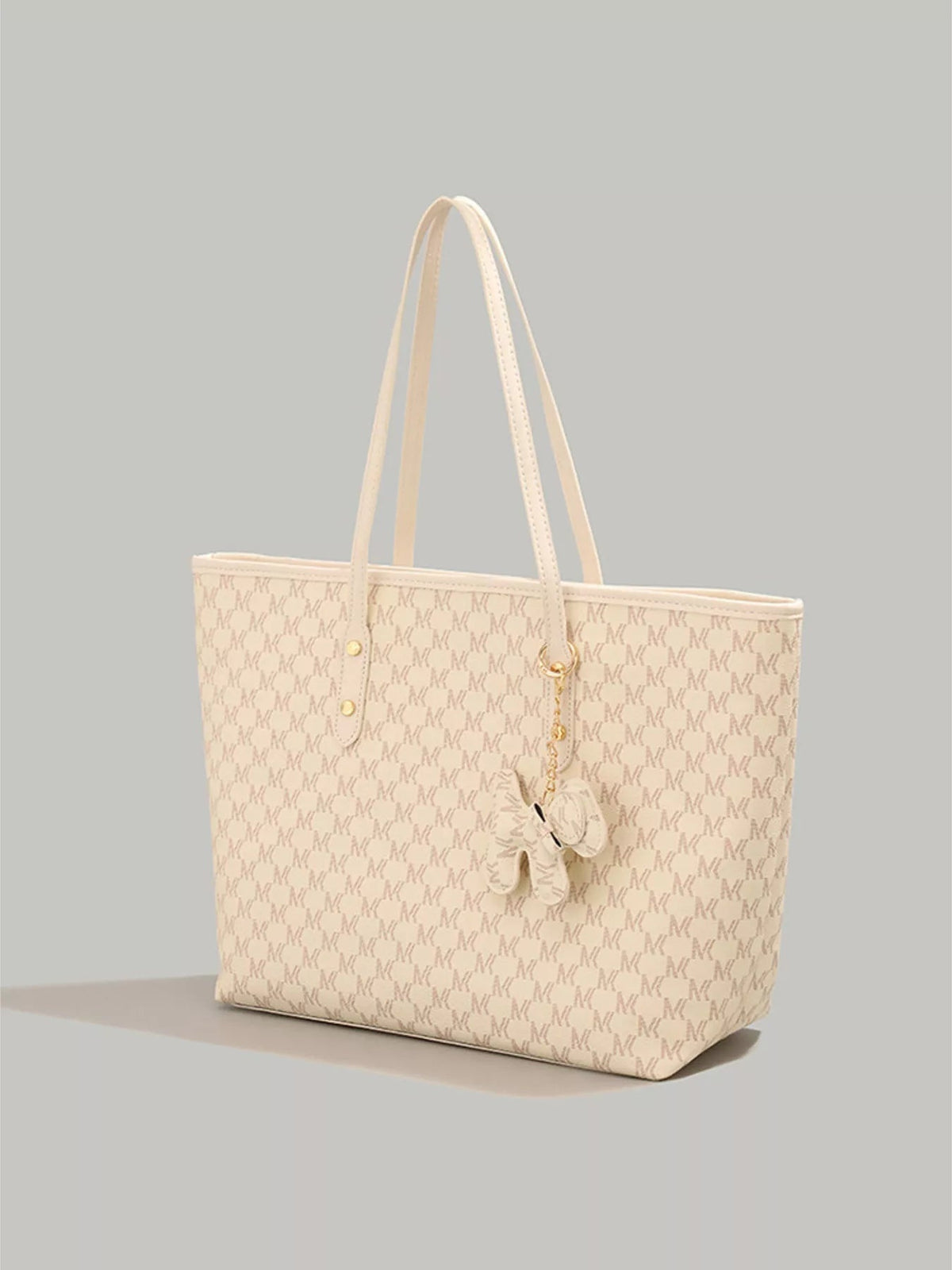 Large cream PU leather tote bag with a structured silhouette, long shoulder straps, repeating monogram pattern, and a dangling dog charm.