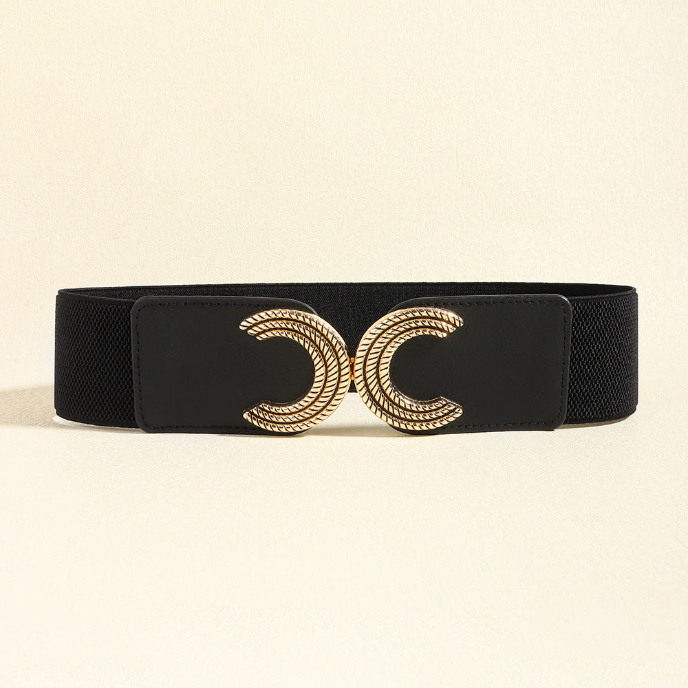 Black elastic waist belt with a wide structured band, stitched PU panels, and a sculptural gold double C buckle at the center.