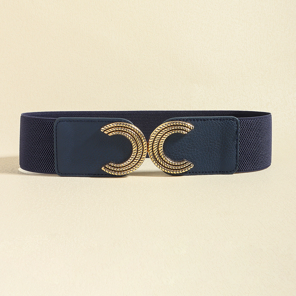 A wide black elastic belt features a structured band and sculptural gold double C buckle for a polished, statement-making waist-defining finish.