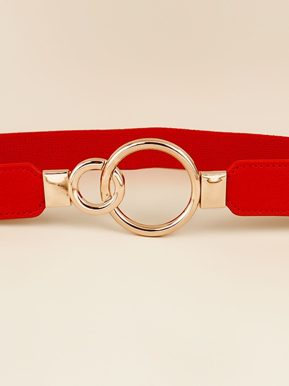Red elastic PU belt featuring a polished gold-tone alloy double-ring buckle, stitched edges, and a streamlined 1-inch profile.