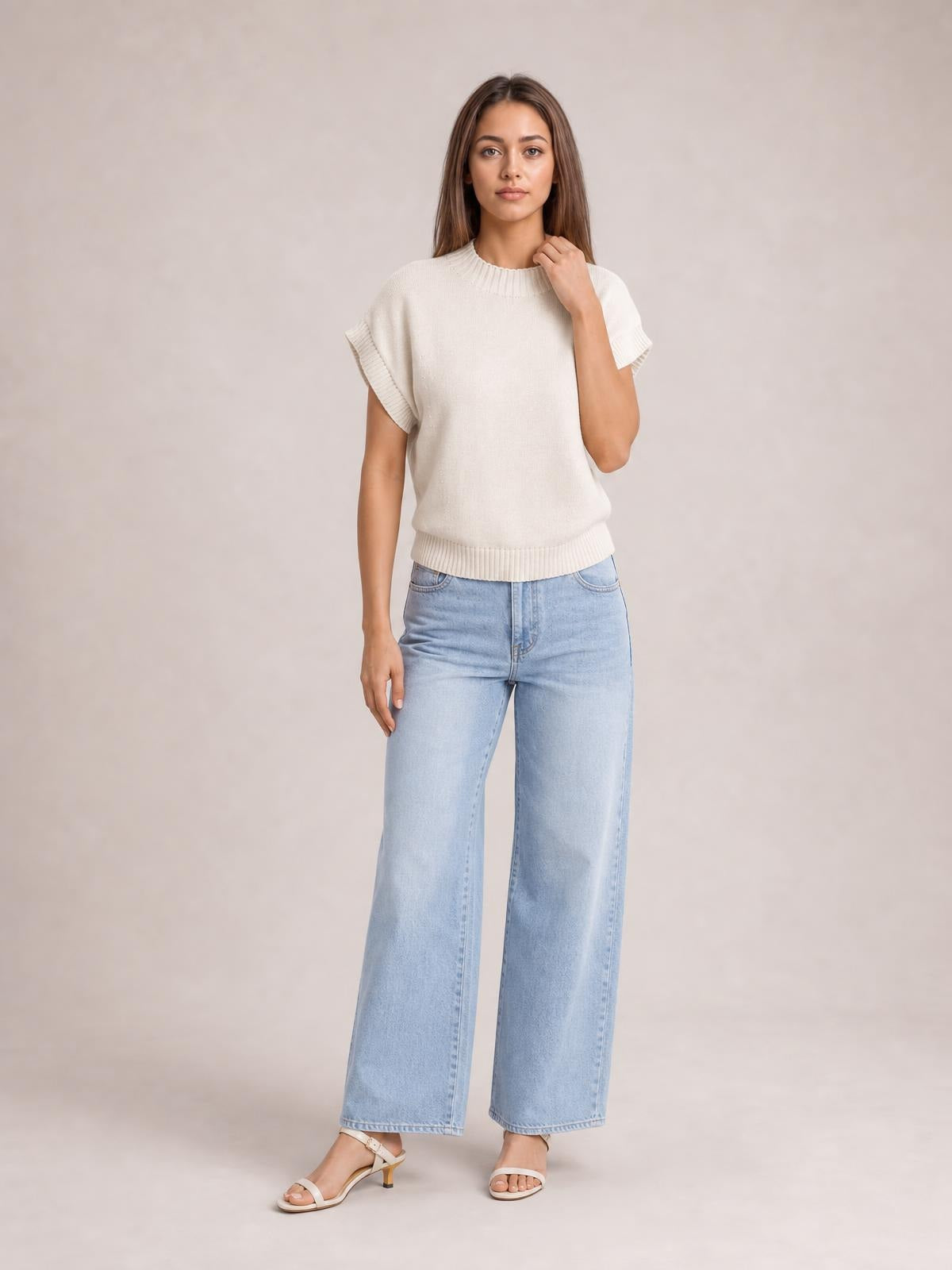 Model wears an ivory mock neck short sleeve sweater with ribbed collar, cuffs, and hem in a relaxed straight silhouette, touching the neckline.