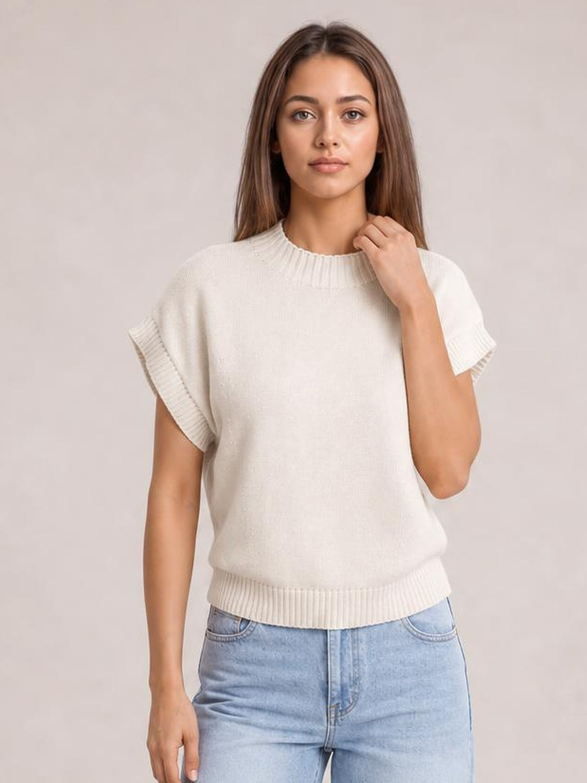 Model poses in a white mock neck short sleeve sweater with ribbed collar, cuffs, and hem, featuring a relaxed straight silhouette.