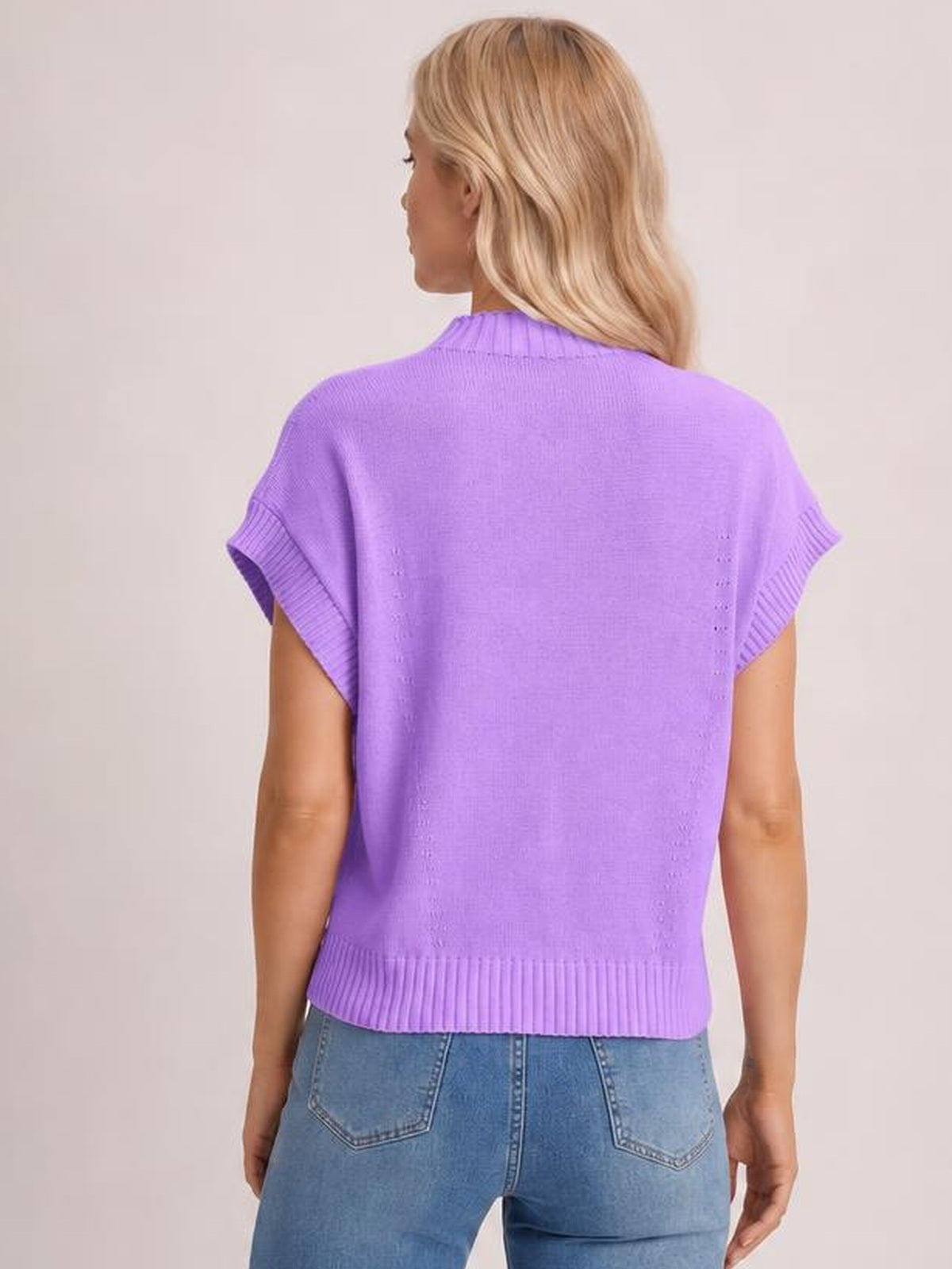 Model shown from behind wearing a purple mock neck short sleeve sweater with a relaxed silhouette and ribbed neckline, sleeve cuffs, and hem.