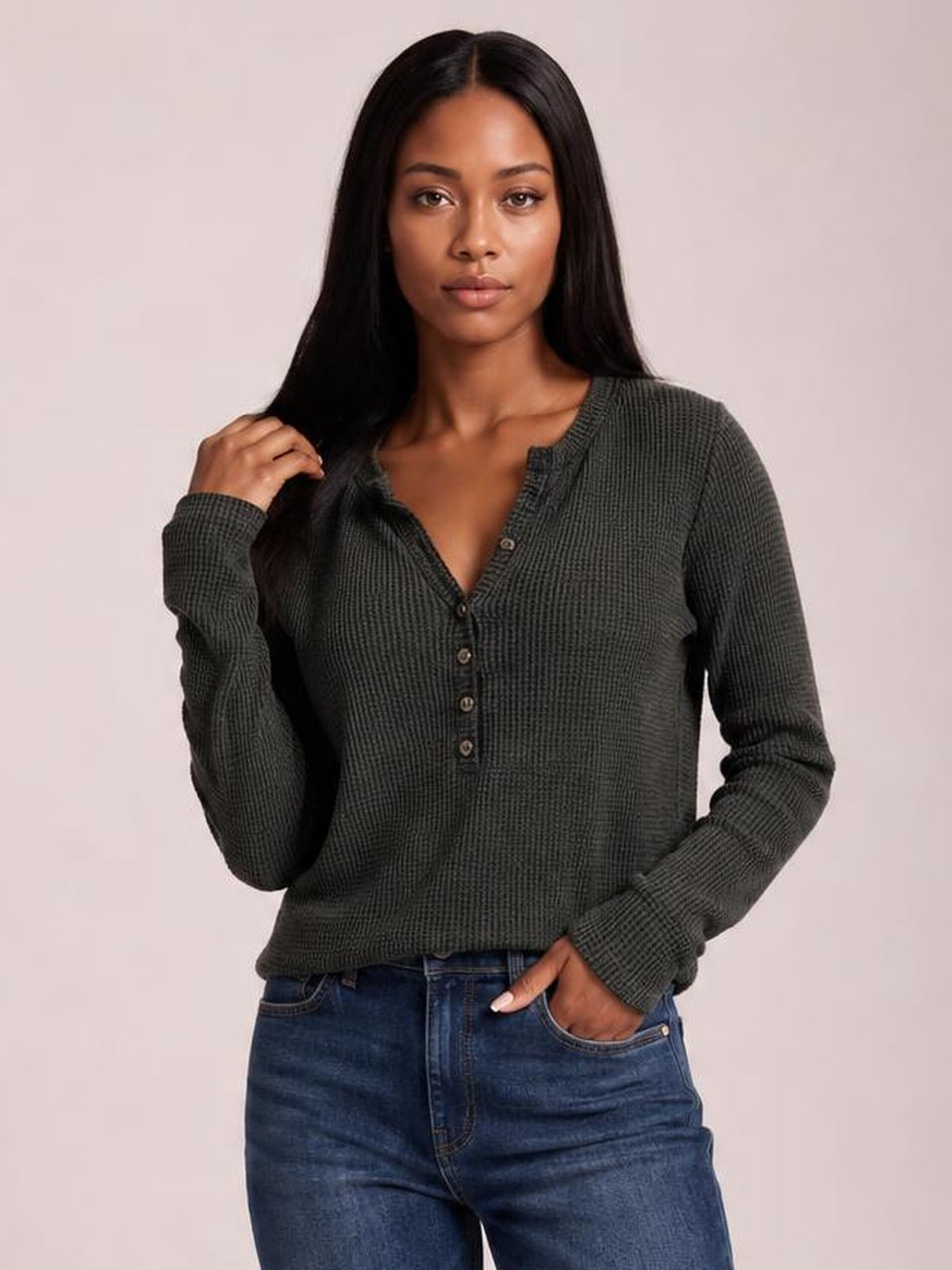 A model poses in a dark charcoal long-sleeve T-shirt with a notched neckline, button placket, textured knit construction, and a relaxed silhouette.