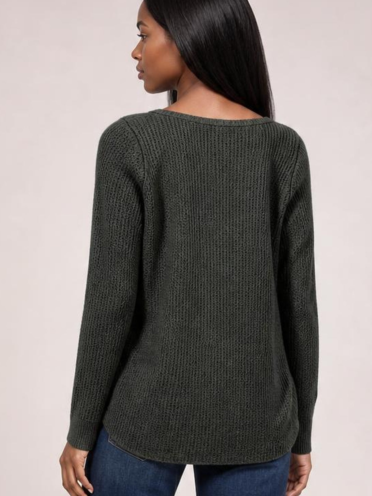 Model shown from behind wearing a dark olive notched long sleeve T-shirt with a textured knit, rounded neckline, relaxed silhouette, and curved hem.
