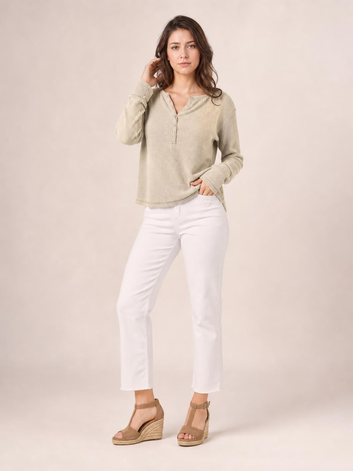 Model poses in a relaxed taupe long sleeve T-shirt with a notched neckline, button placket, textured knit fabric, and loose silhouette.