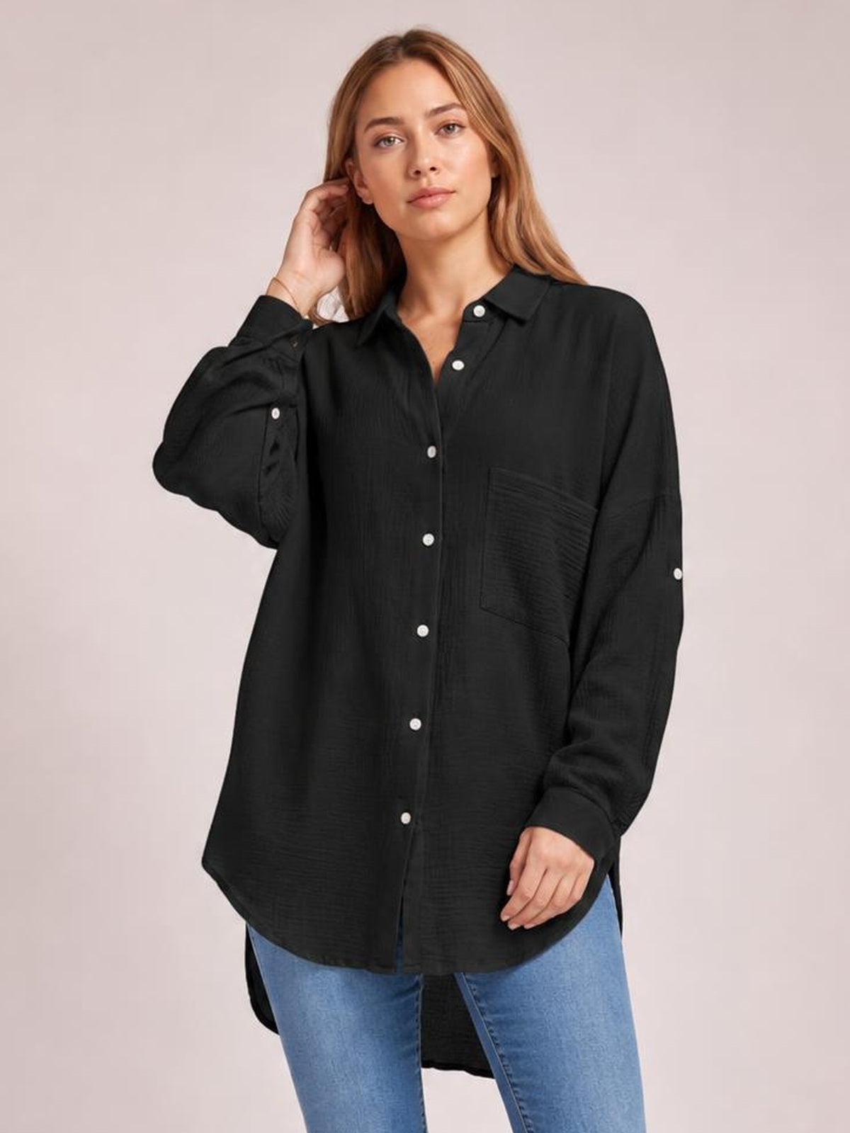 Model wearing a black textured button-up shirt with a collared neckline, long sleeves, front buttons, chest pocket, and curved relaxed silhouette.